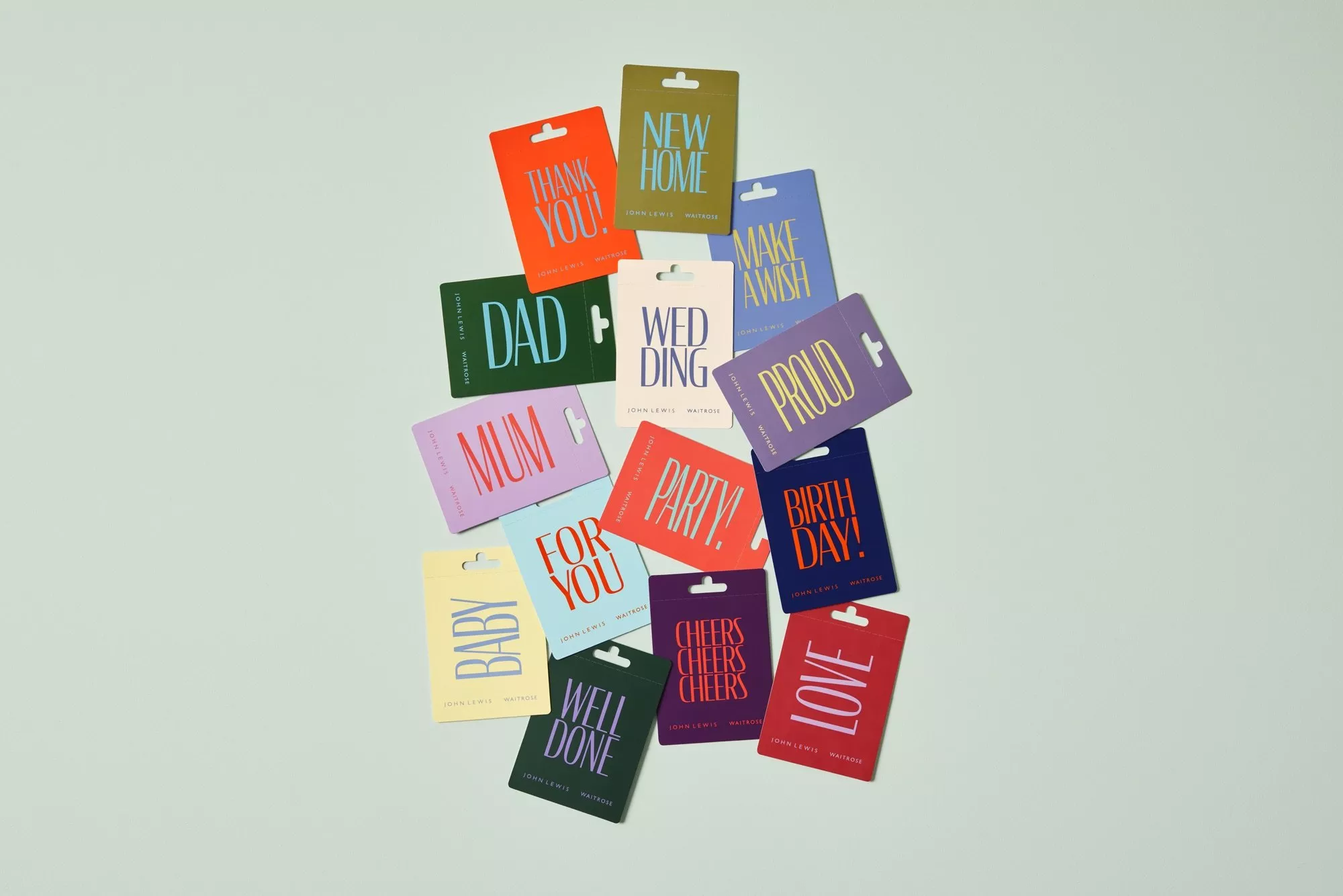 Colourful gift cards arranged on a pale background, featuring birthday, wedding, new home and love messages