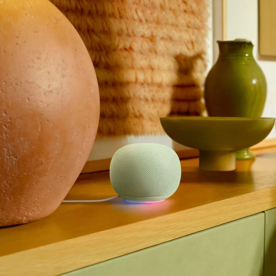 Mint smart speaker on wooden sideboard with ceramic vase and bowl, cosy modern home decor scene