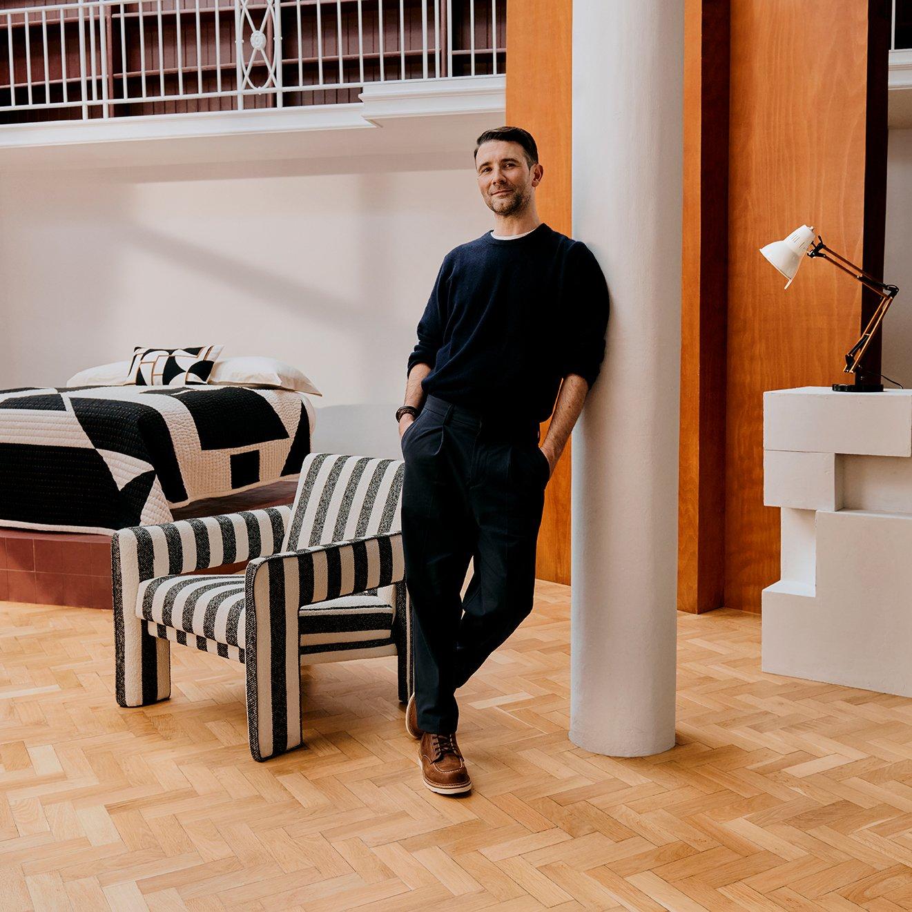 John Lewis x John Cooper standing next to his designs