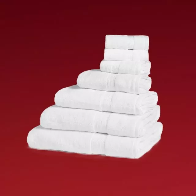 Stack of fluffy white bath towels on a red background, luxury bathroom linen set for home or hotel use