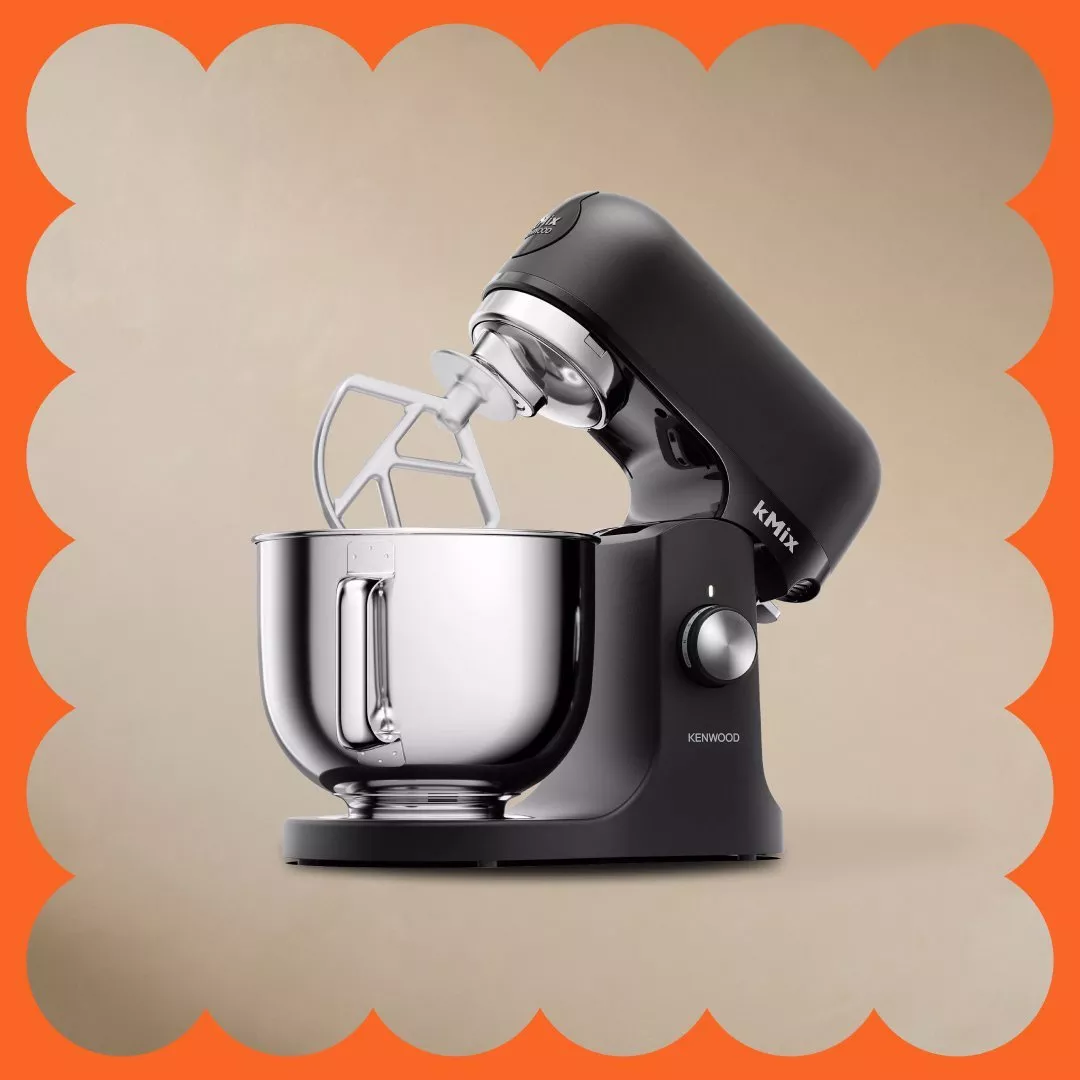 Modern Kenwood kMix stand mixer with bowl and paddle attachment, set against an orange scalloped border.