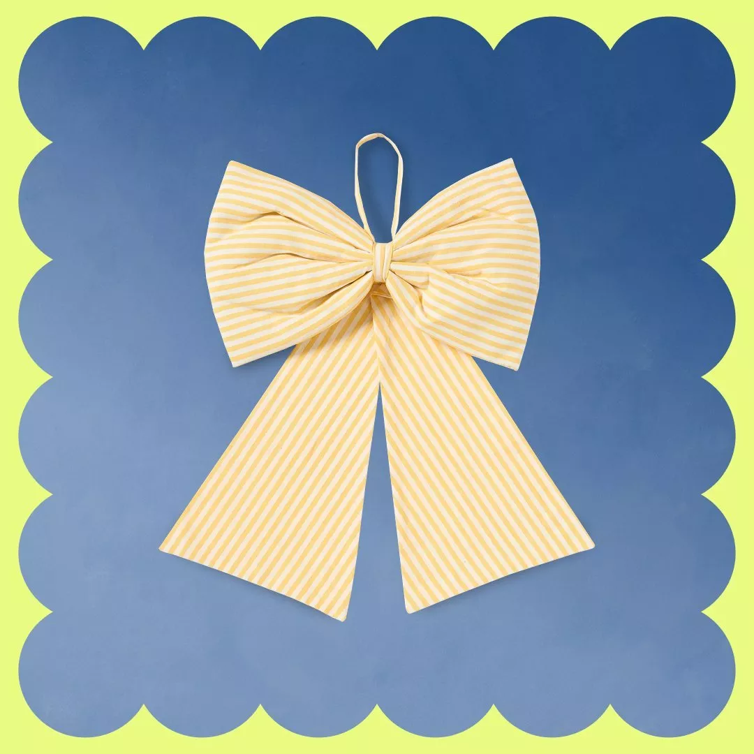 Yellow striped bow on a blue background with a wavy yellow border, creating a playful look.