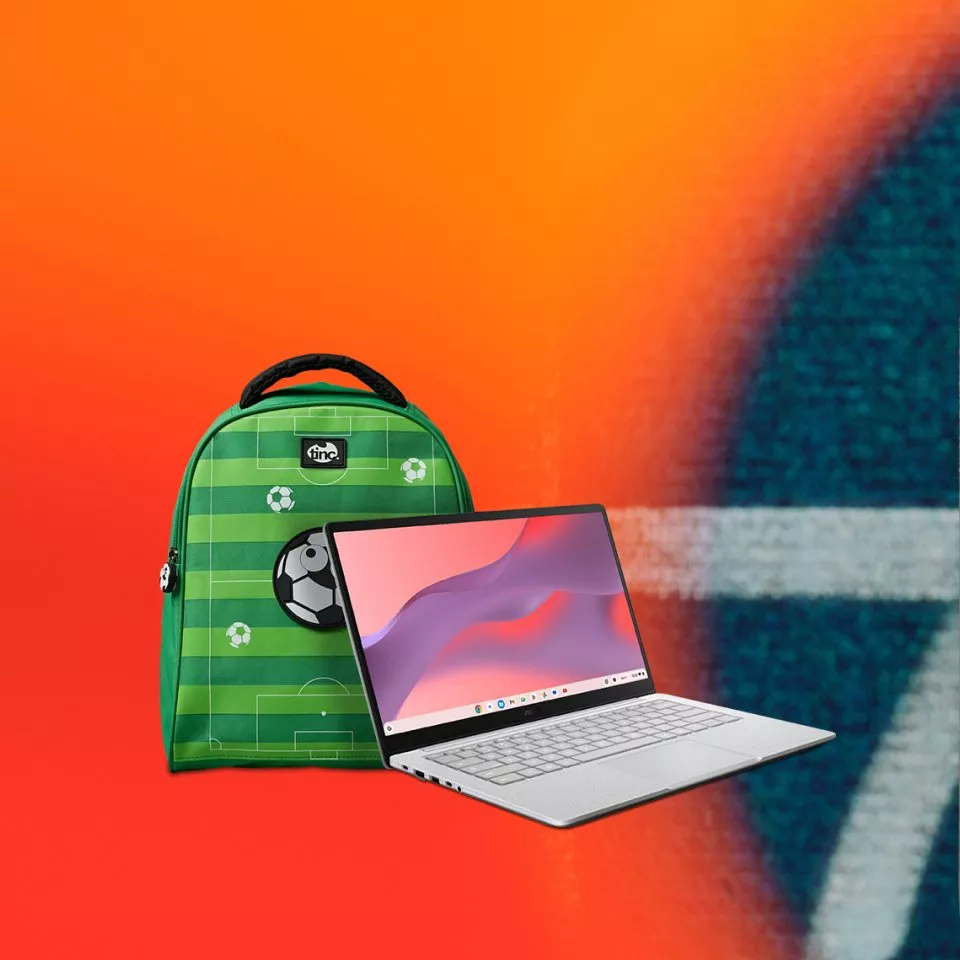 Green football-themed school backpack beside a silver laptop on bright orange background, kids back to school tech setup