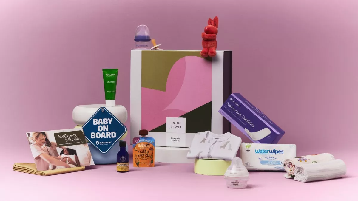 John Lewis new parent starter gift box with baby essentials, wipes, muslin cloths and skincare on pink backdrop