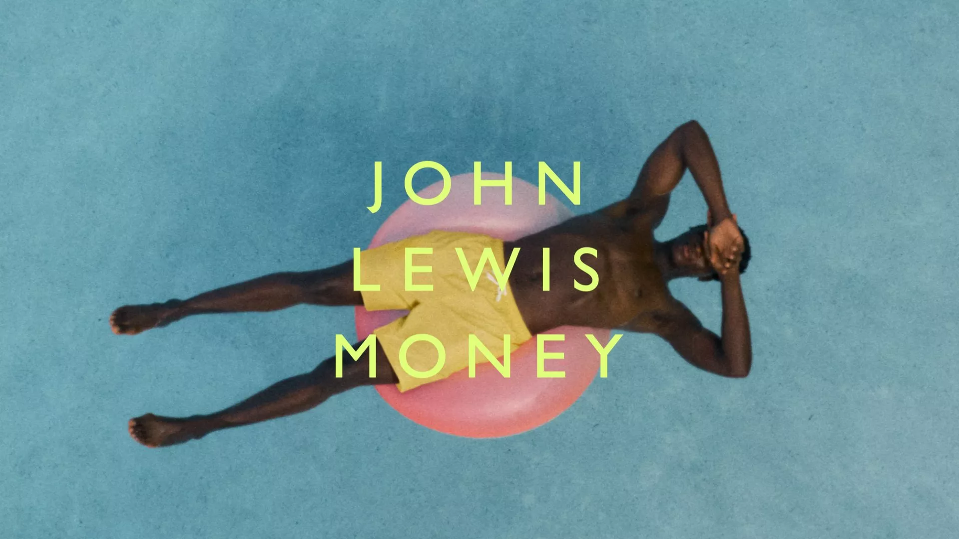 Person relaxing on a pool float in water. Text overlay reads "John Lewis Money" in bold yellow font.