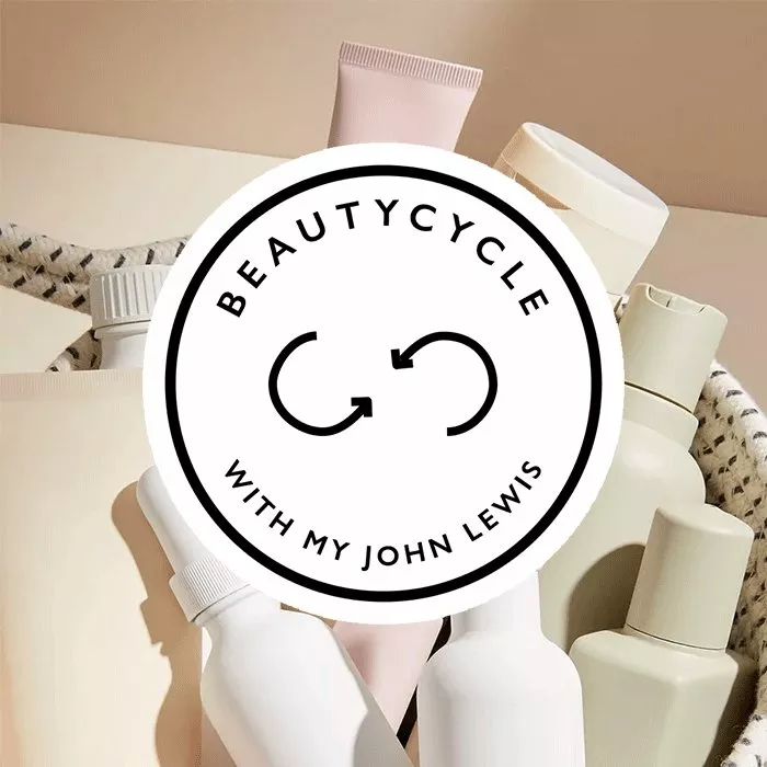 BeautyCycle with my John Lewis logo over reusable cosmetic bottles and tubes in a wicker basket on beige background