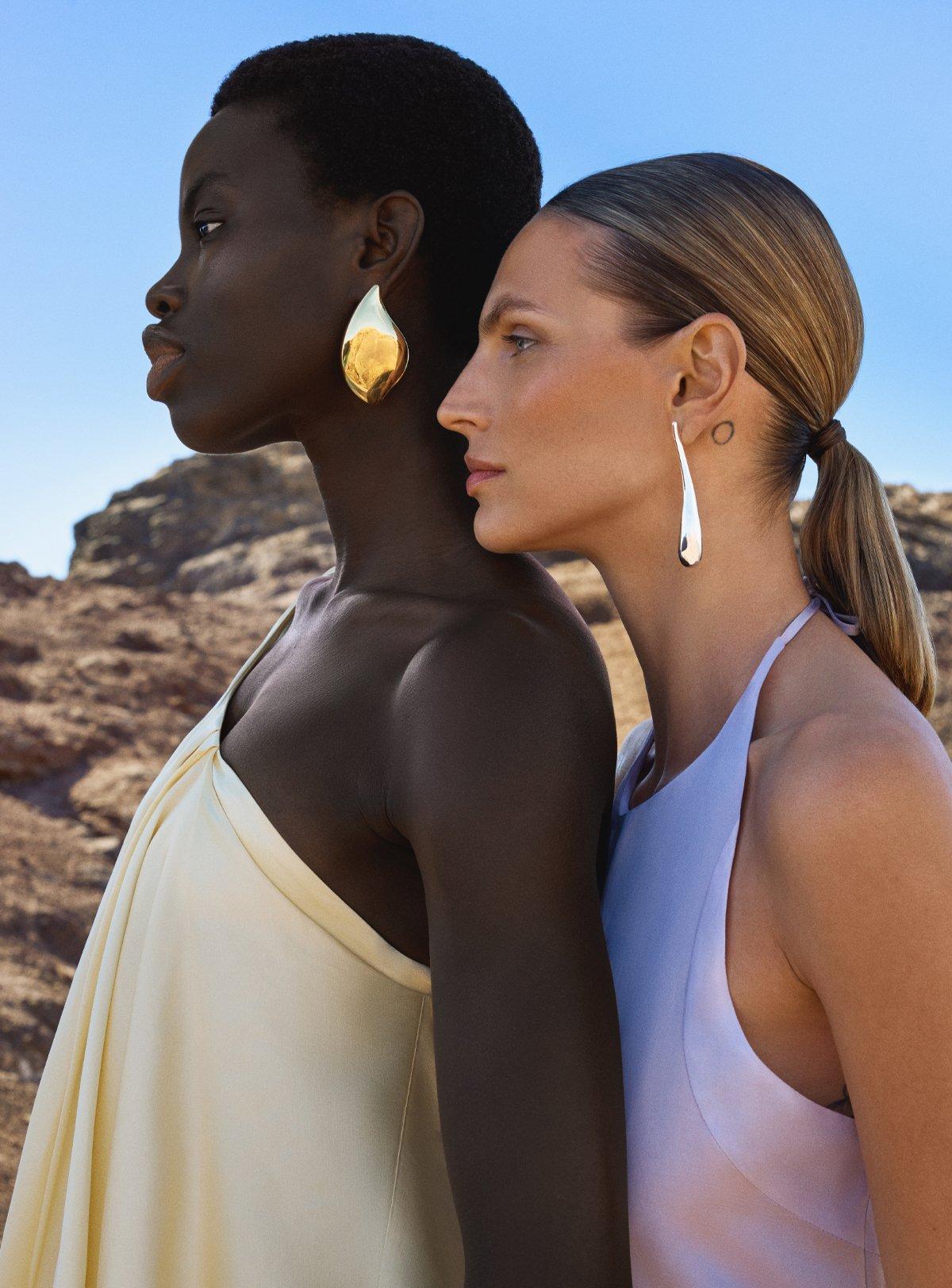 two women wearing bold earings on a sunny day