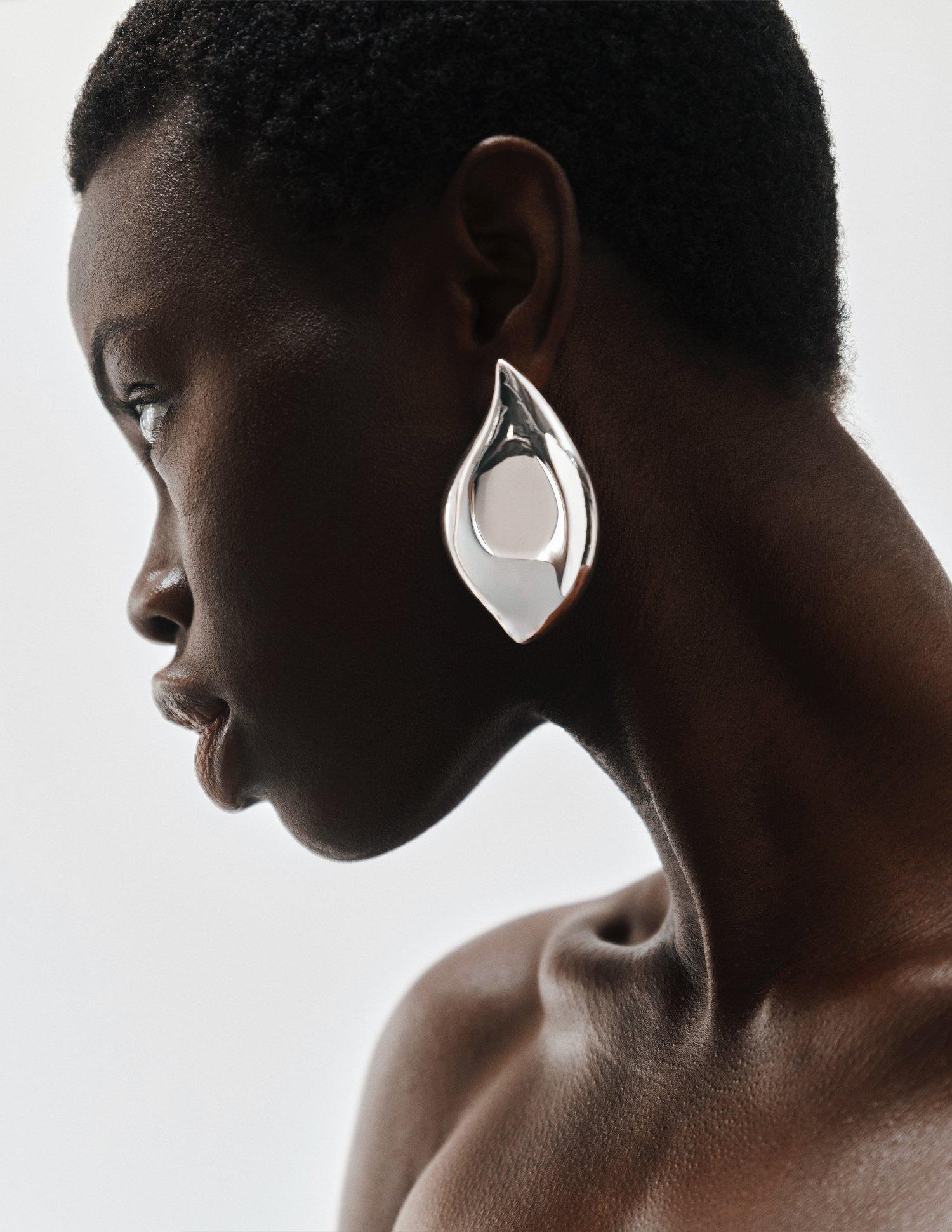 a women wearing a big silver bold earing