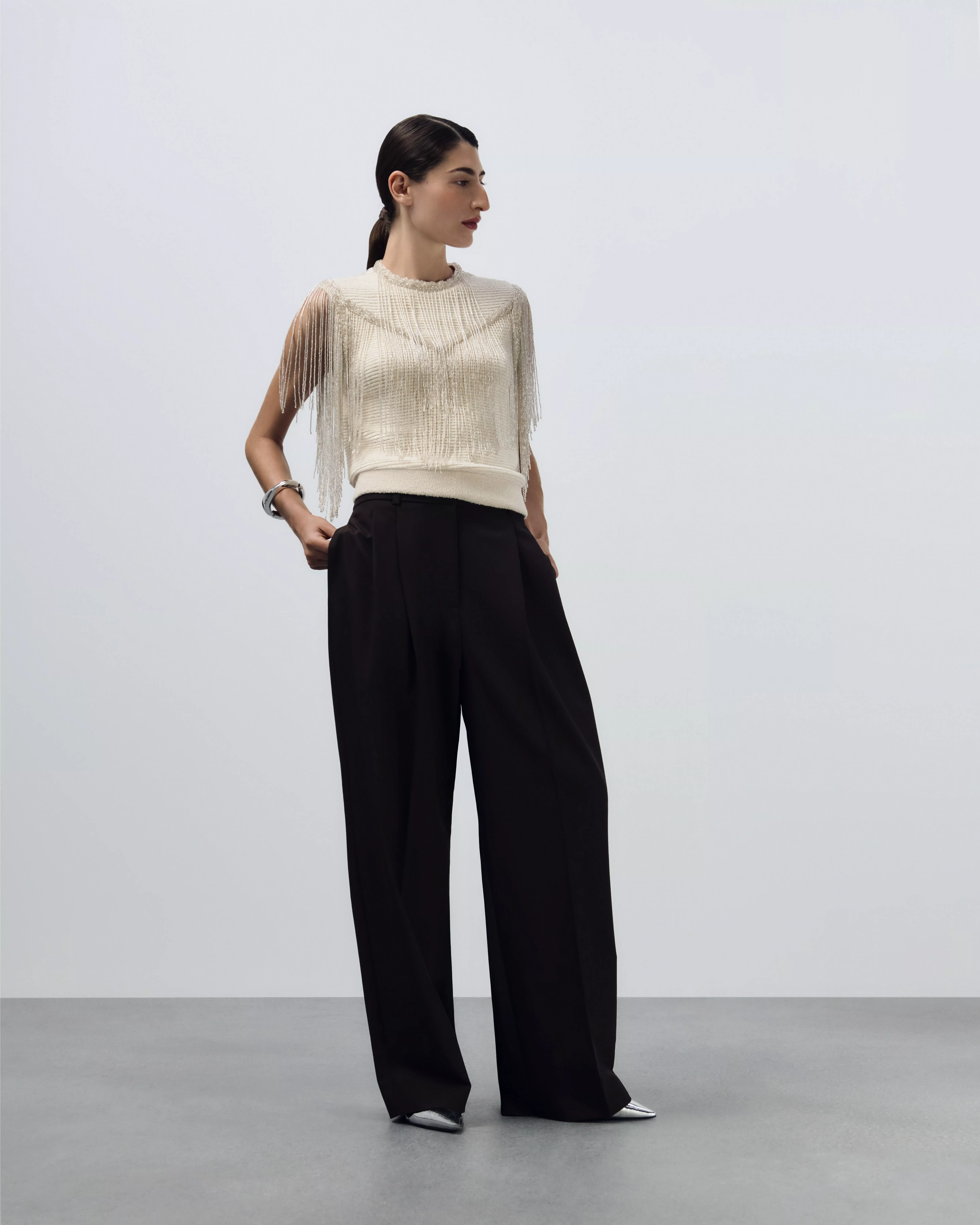 woman in white sequin top and skirt co-ord with heels