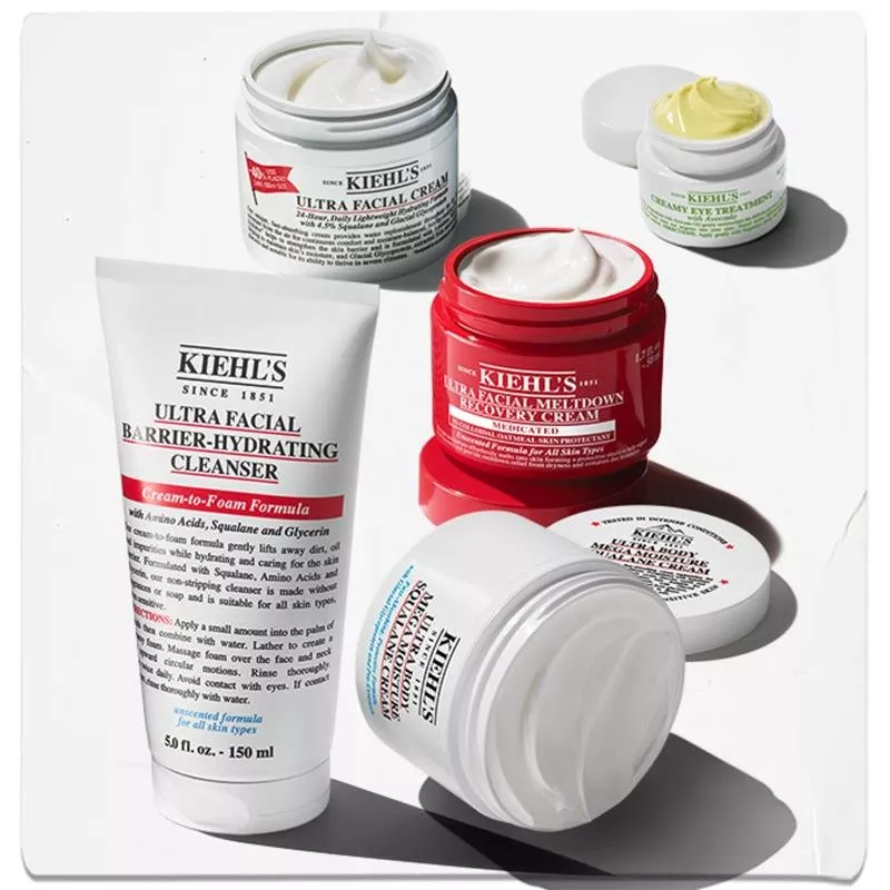 Kiehl's skincare products including cleansers and creams in various containers arranged on a white surface.