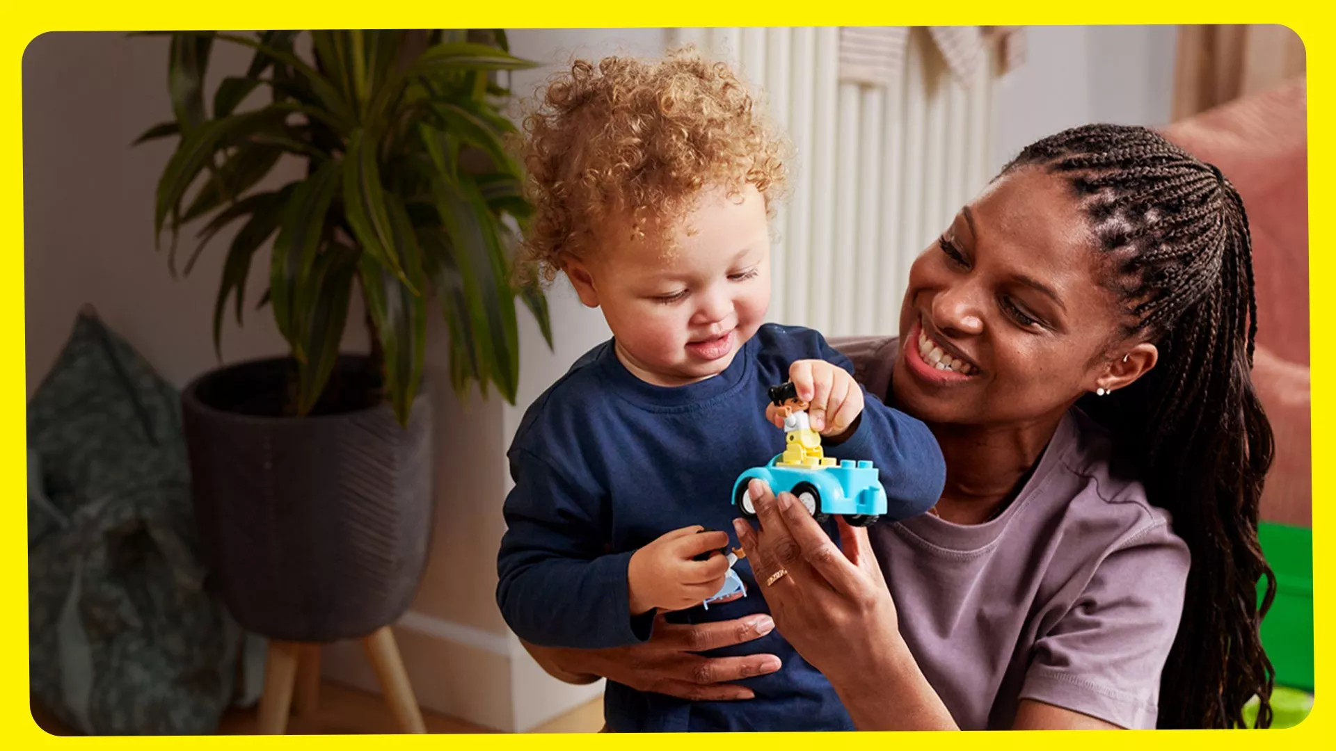 Mother and toddler playing with a toy car indoors, supporting early learning, bonding and child development at home