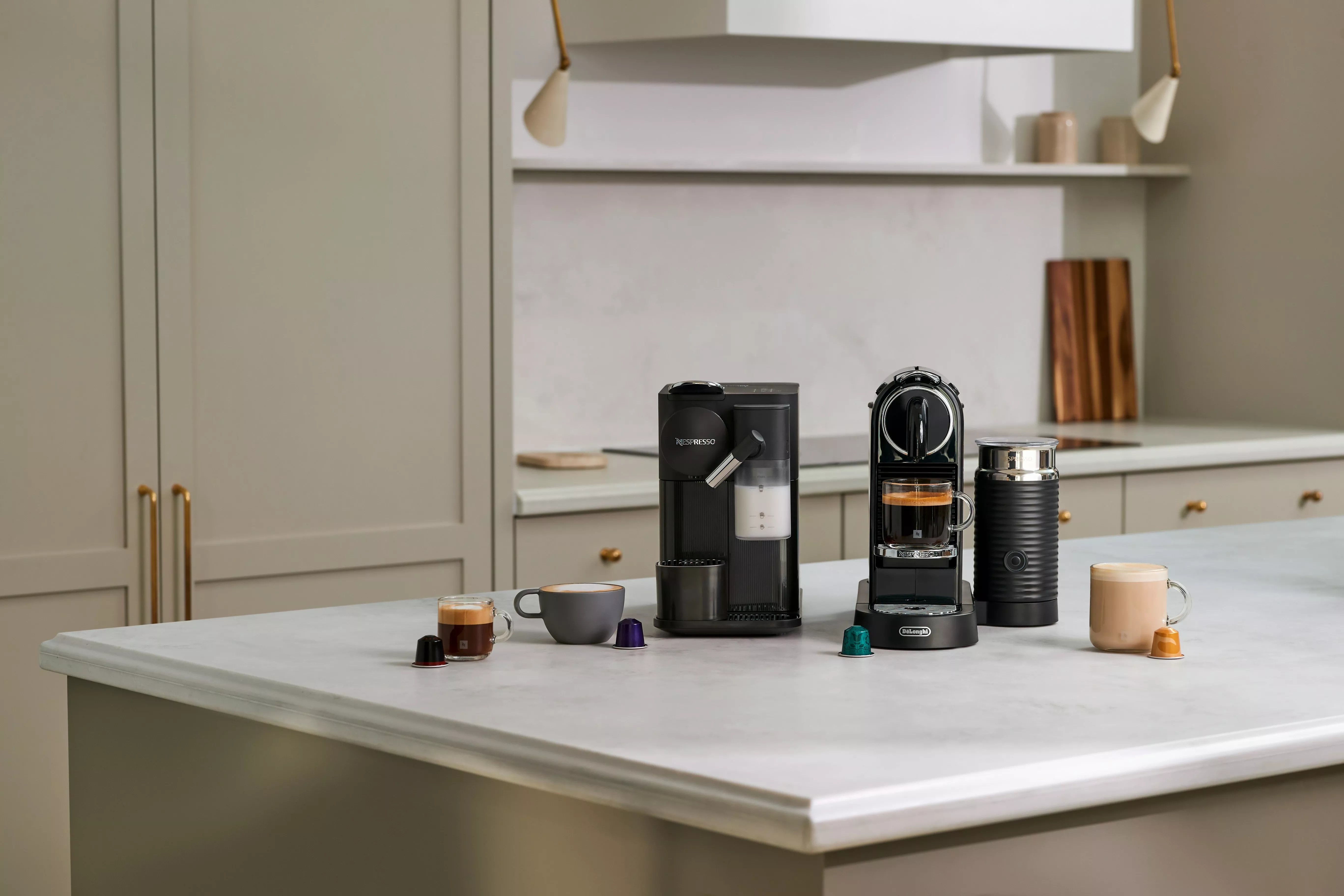 Nespresso Vertuo, milk frother, glass mugs and capsules displayed on a kitchen counter