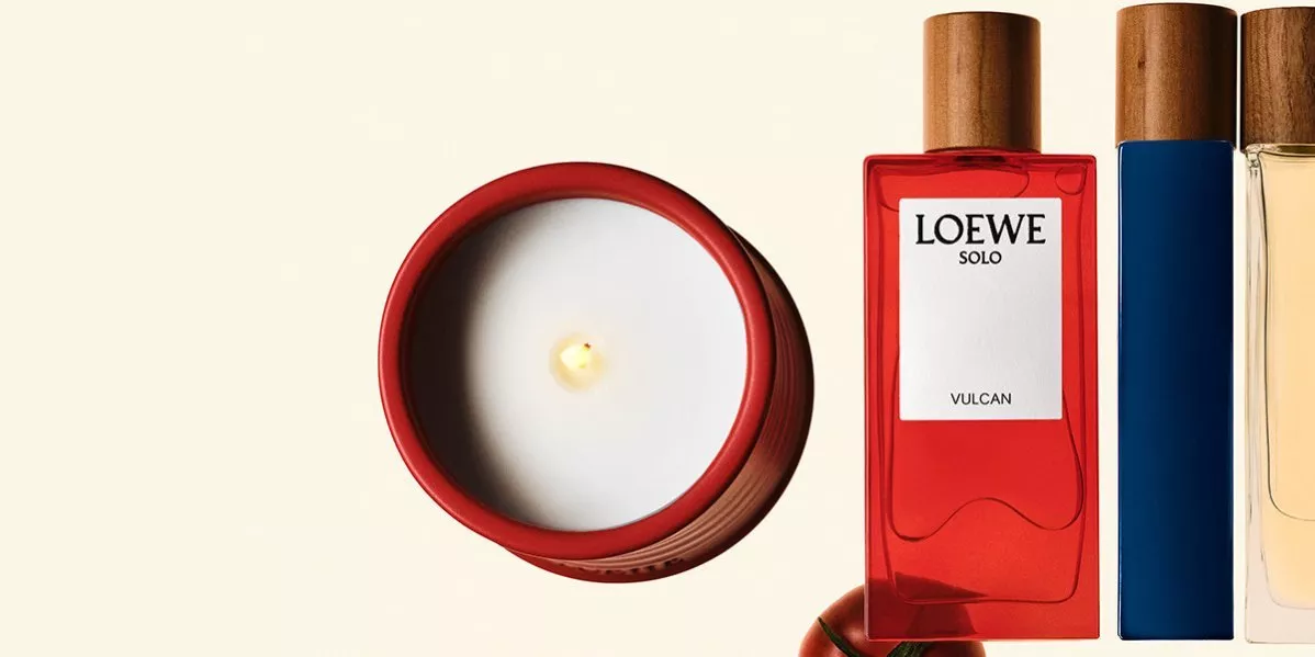 This is banner for Loewe showing perfumes, a candle and a tomato.