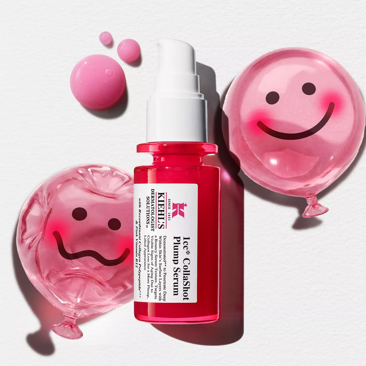 Kiehl's CollaShot Plump Serum bottle in bright pink, surrounded by liquid droplets and two pink smiley-face balloons—one deflated and one fully inflated—on a textured white background.