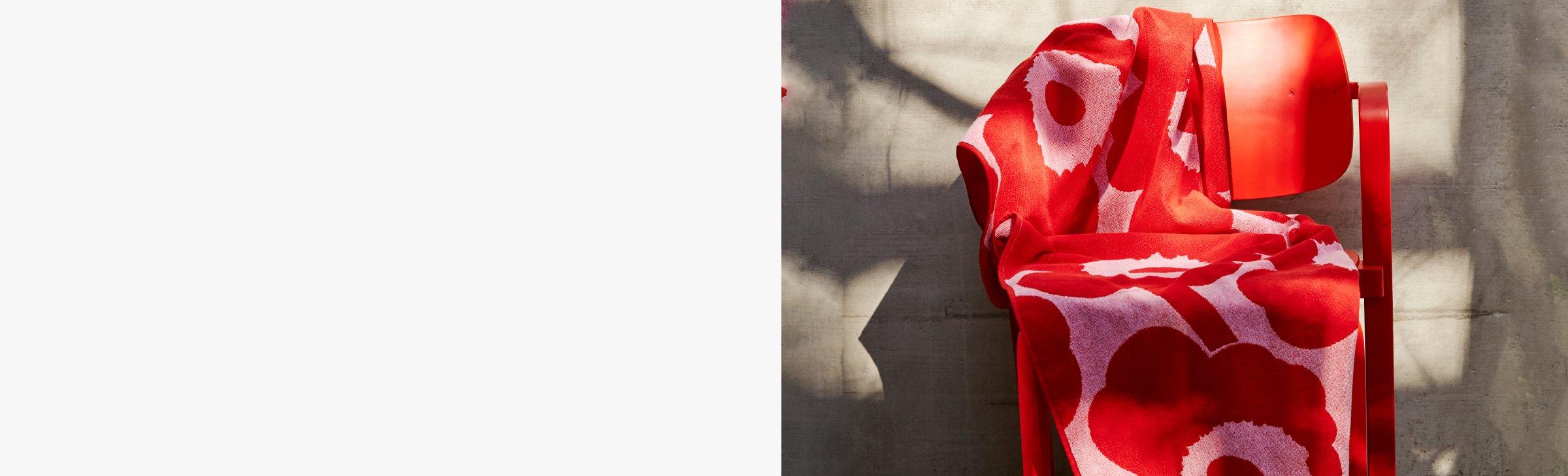 red Marimekko floral towel laid onto a bright red char
