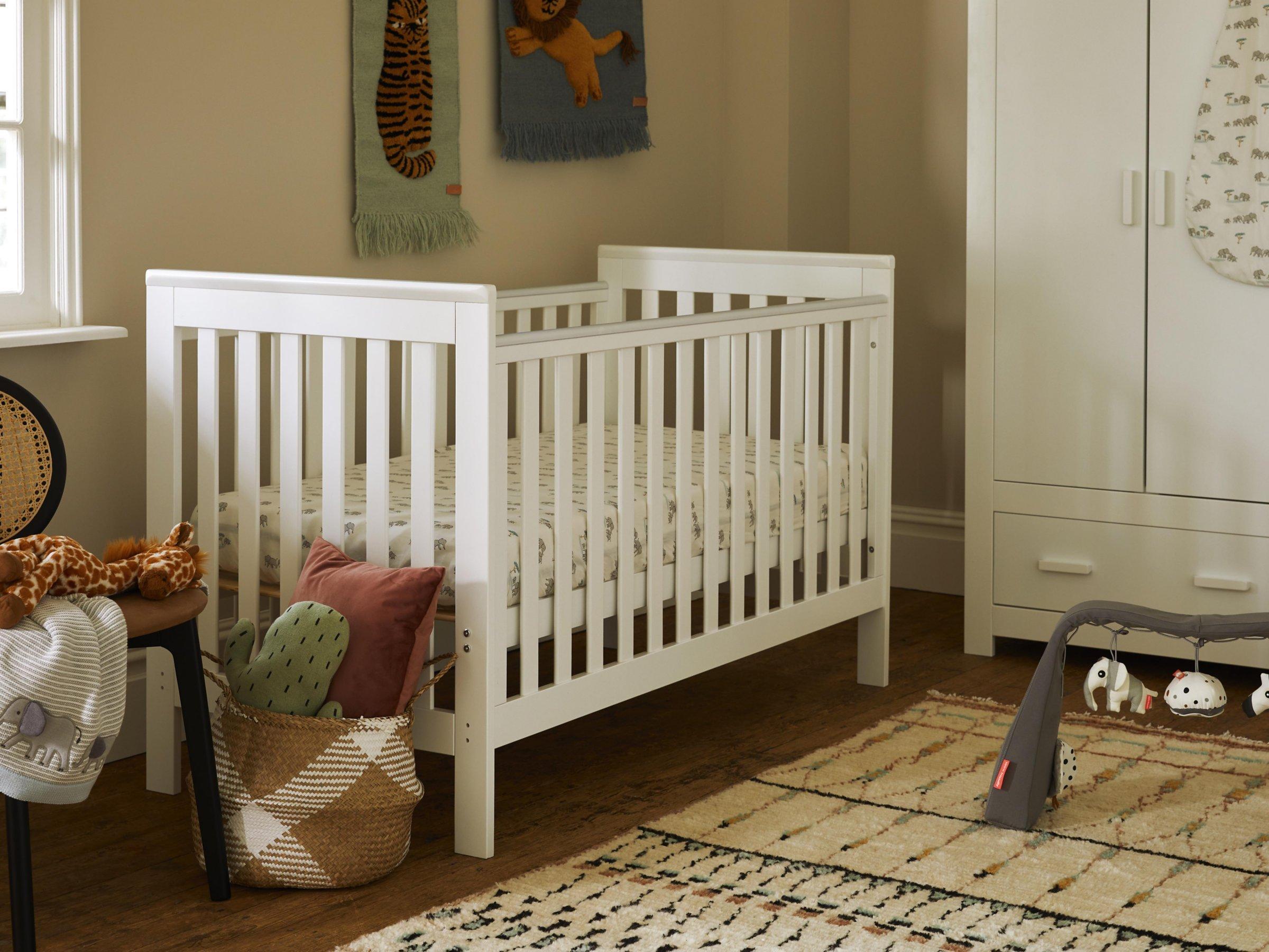 A baby's bed with a wooden headboard