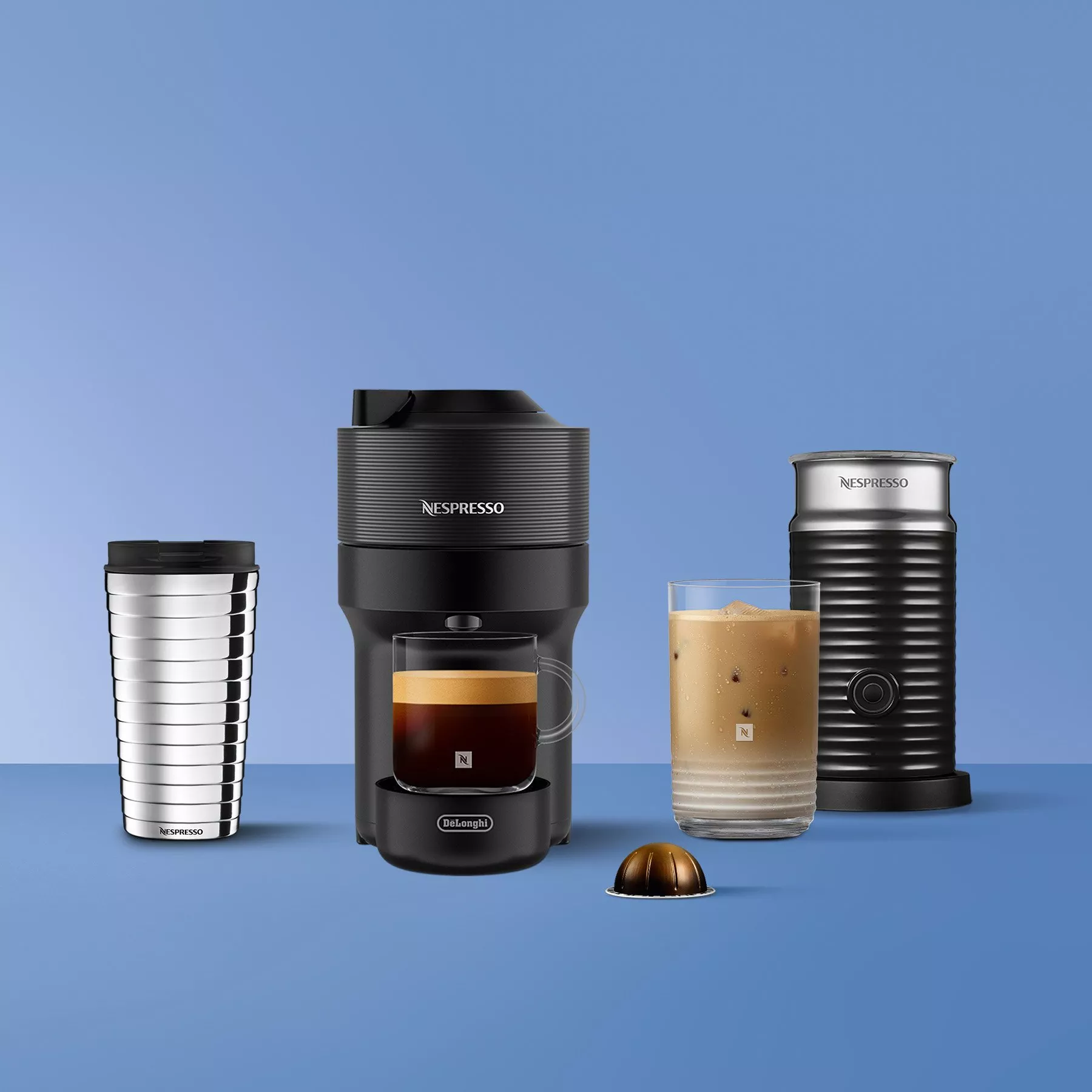 Nespresso Vertuo coffee machine with iced coffee drinks, capsule and ice tray on blue background, studio shot