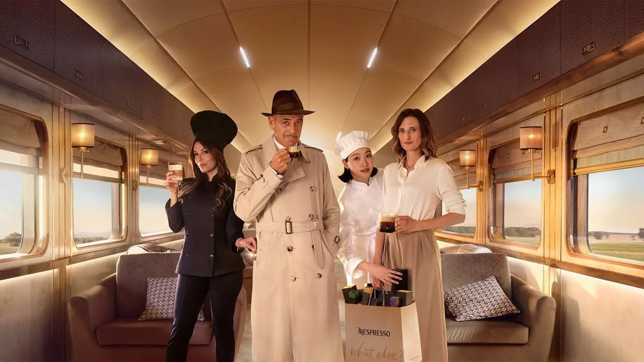 George Clooney alongside others sipping coffee while on a train carriage