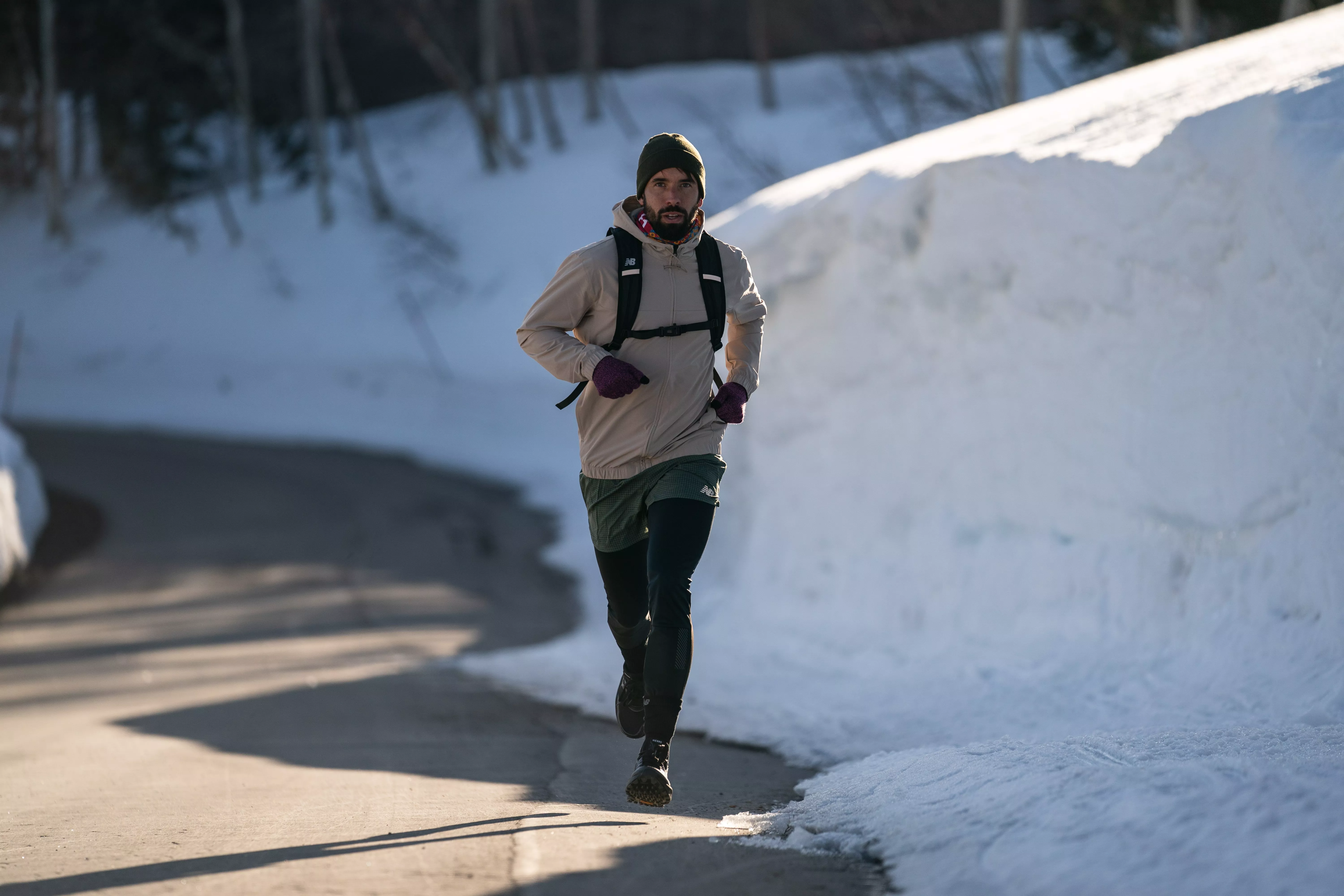 man running in New Balance brand hoodie, shorts and leggings