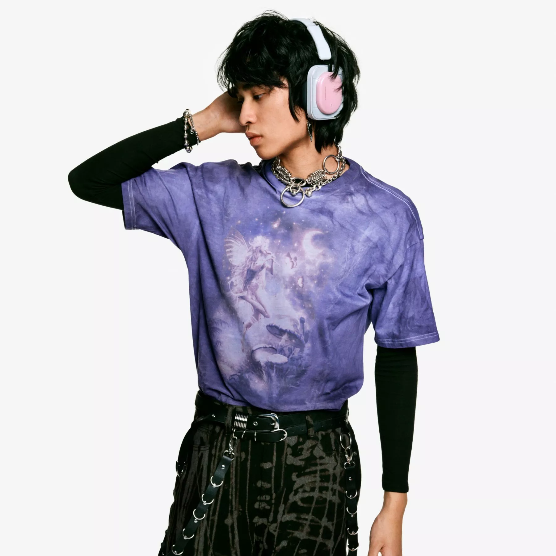 Black headphones with cables, a white pouch, and box packaging on a minimalist grey background.