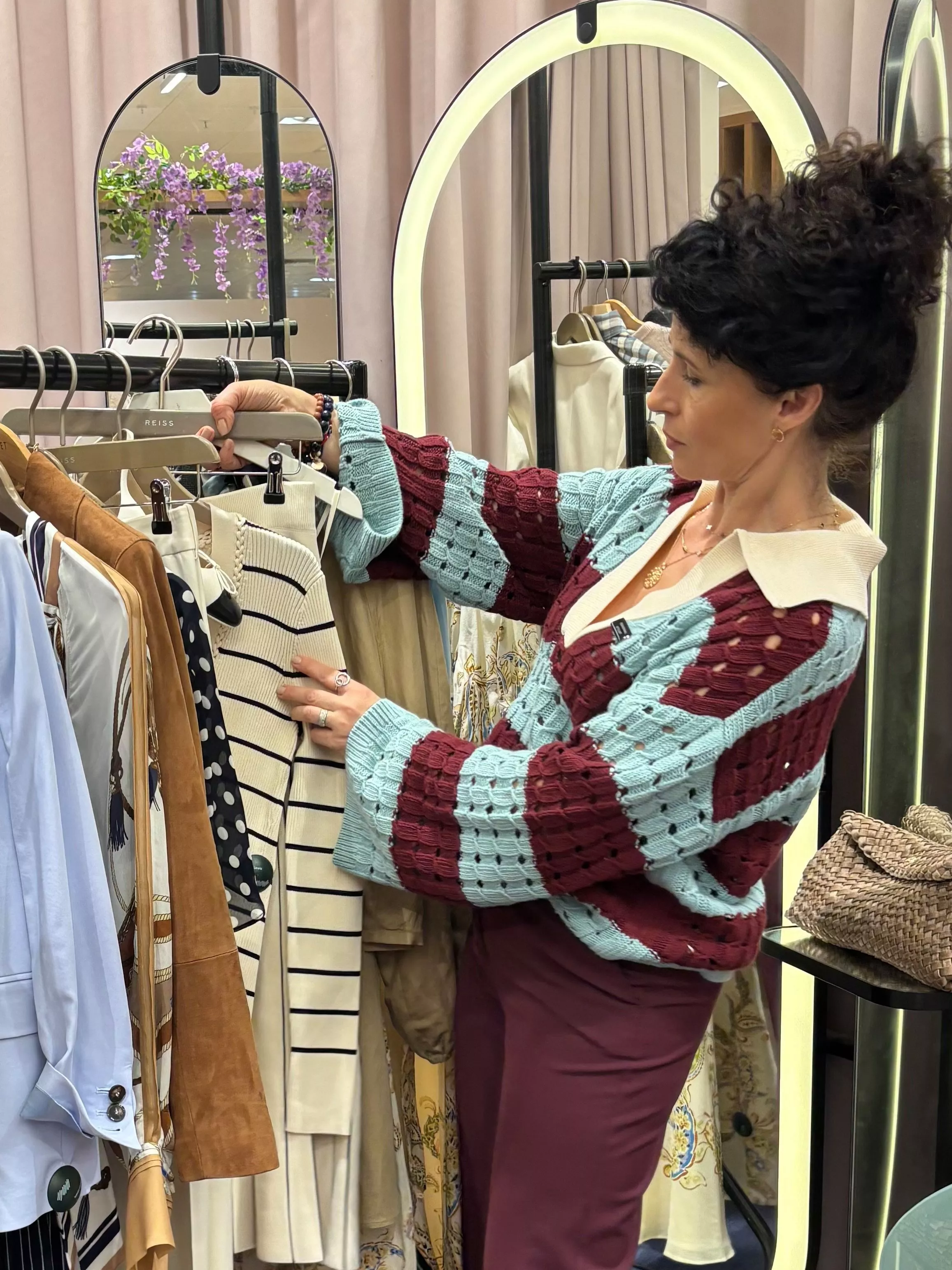 stylist on shop floor picking out clothes