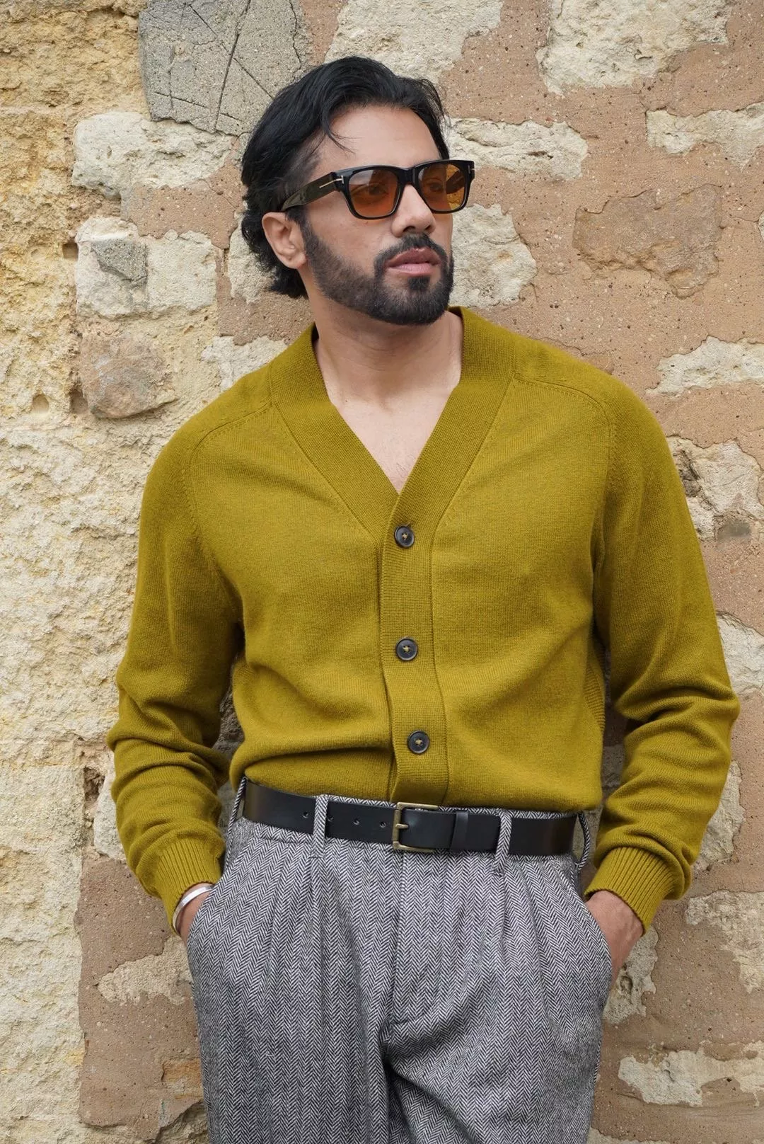 Stylist wearing a green cardigan, belted trousers and sunglasses