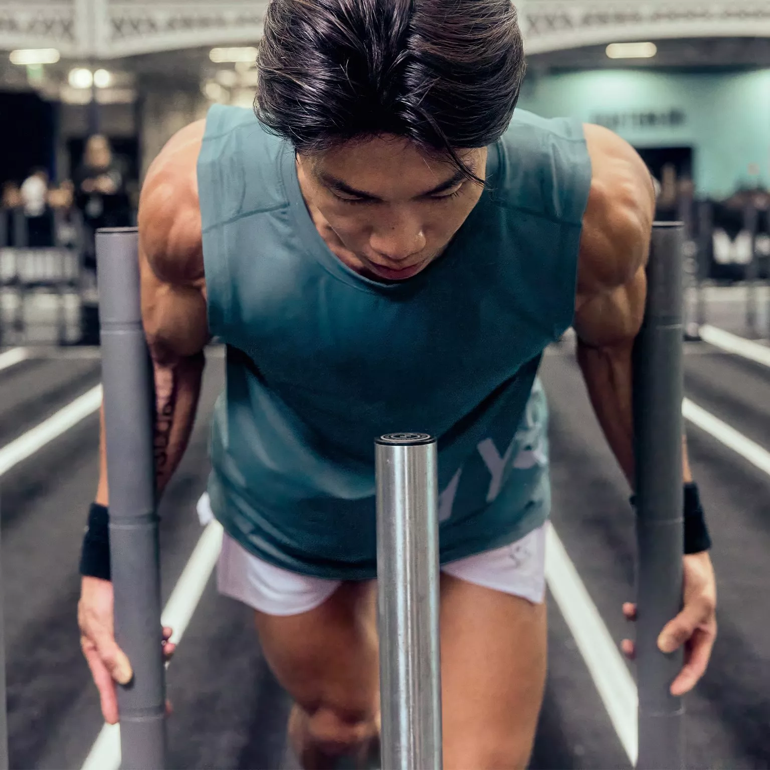 Muscular man pushing weighted sled in gym, intense strength training workout for legs, shoulders and arms