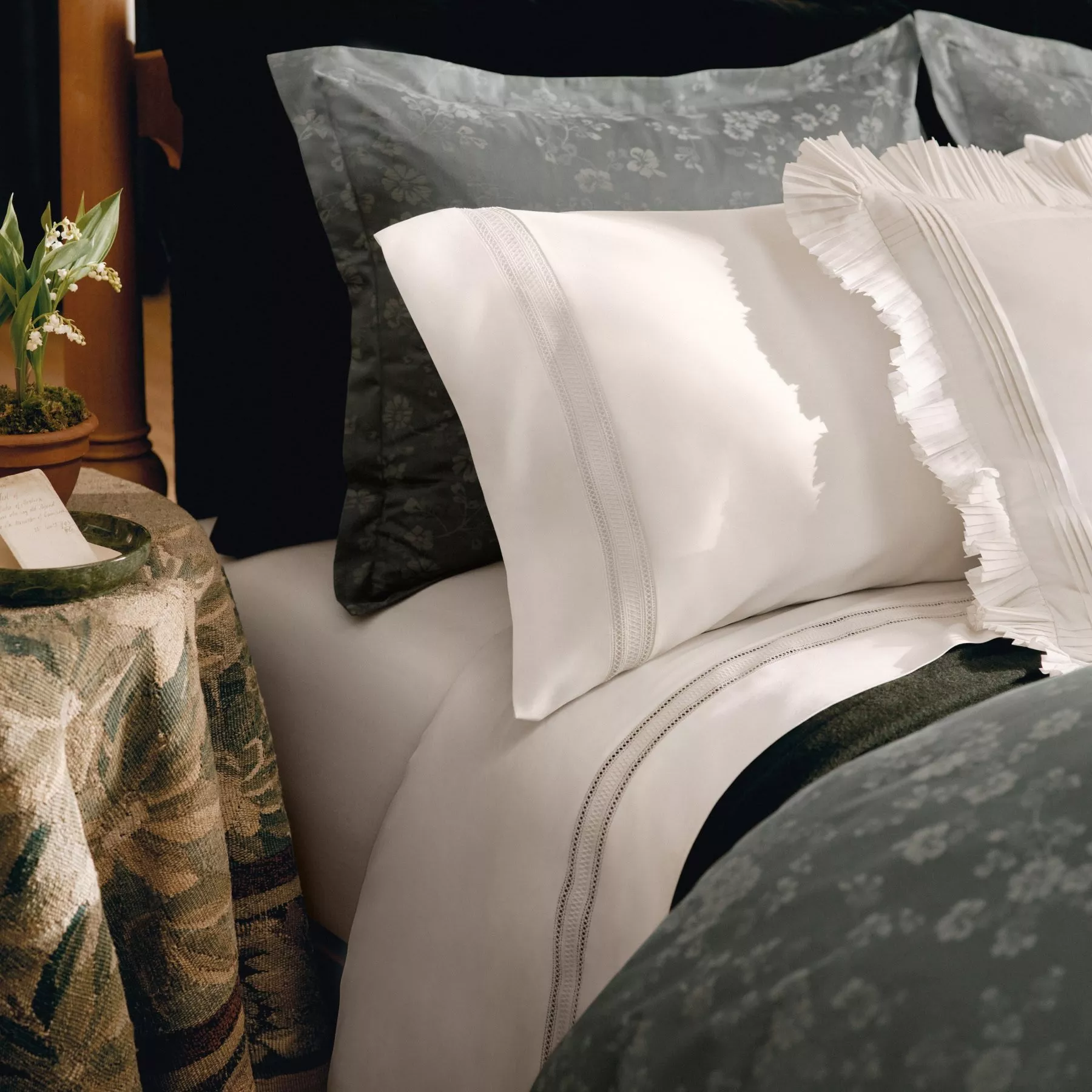 Navy pinstripe bedding set with striped duvet, cushions and tan leather headboard, modern bedroom style