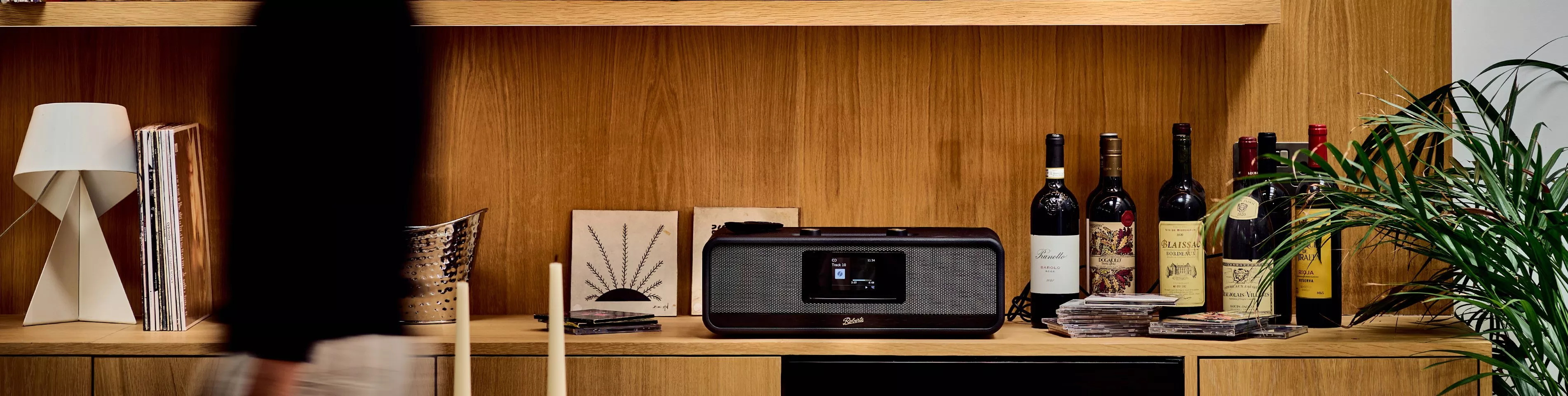 A black Roberts Revere speakers with central display screens against a wooden wall