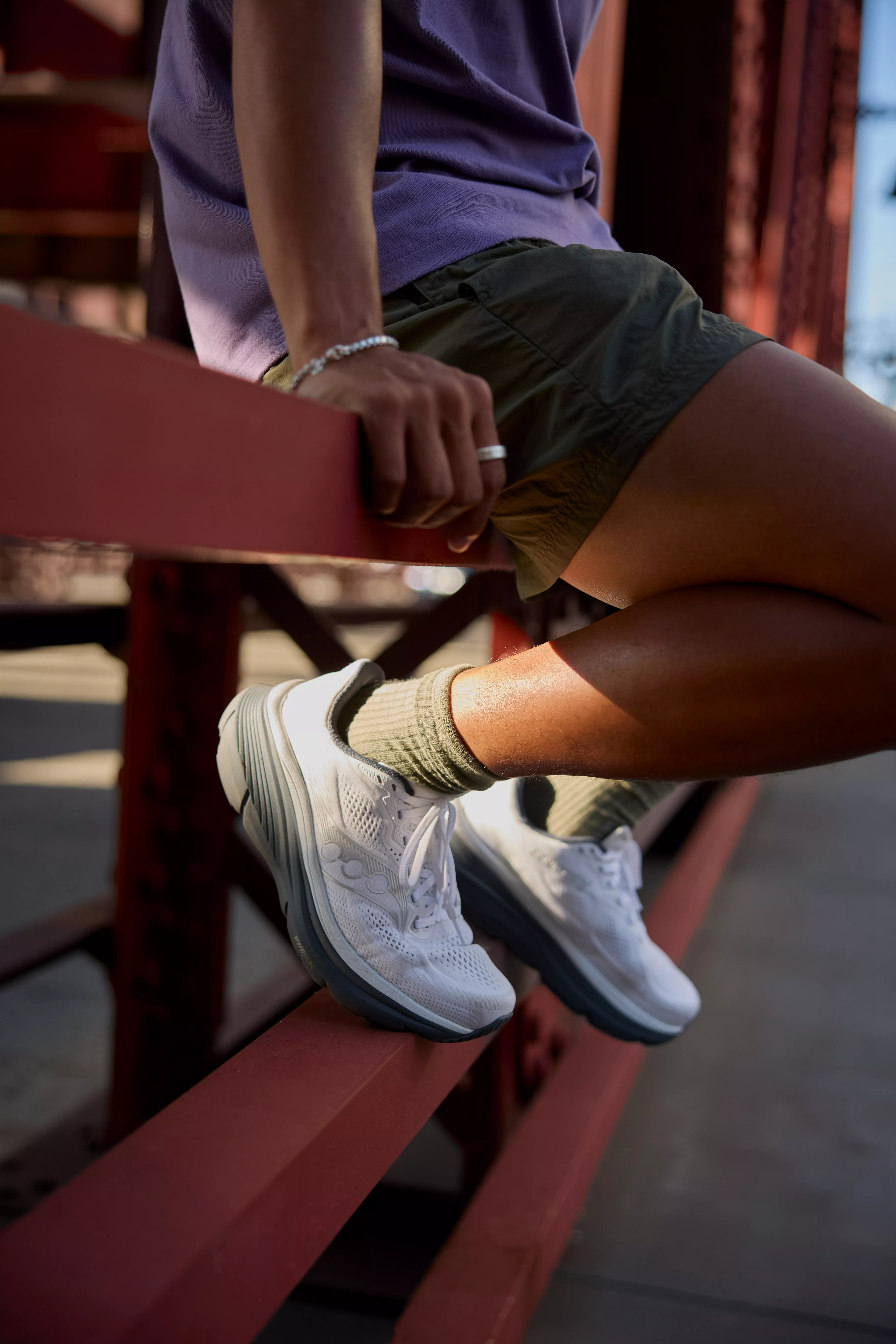 close up of a man wearing running shoes sat down on a bench