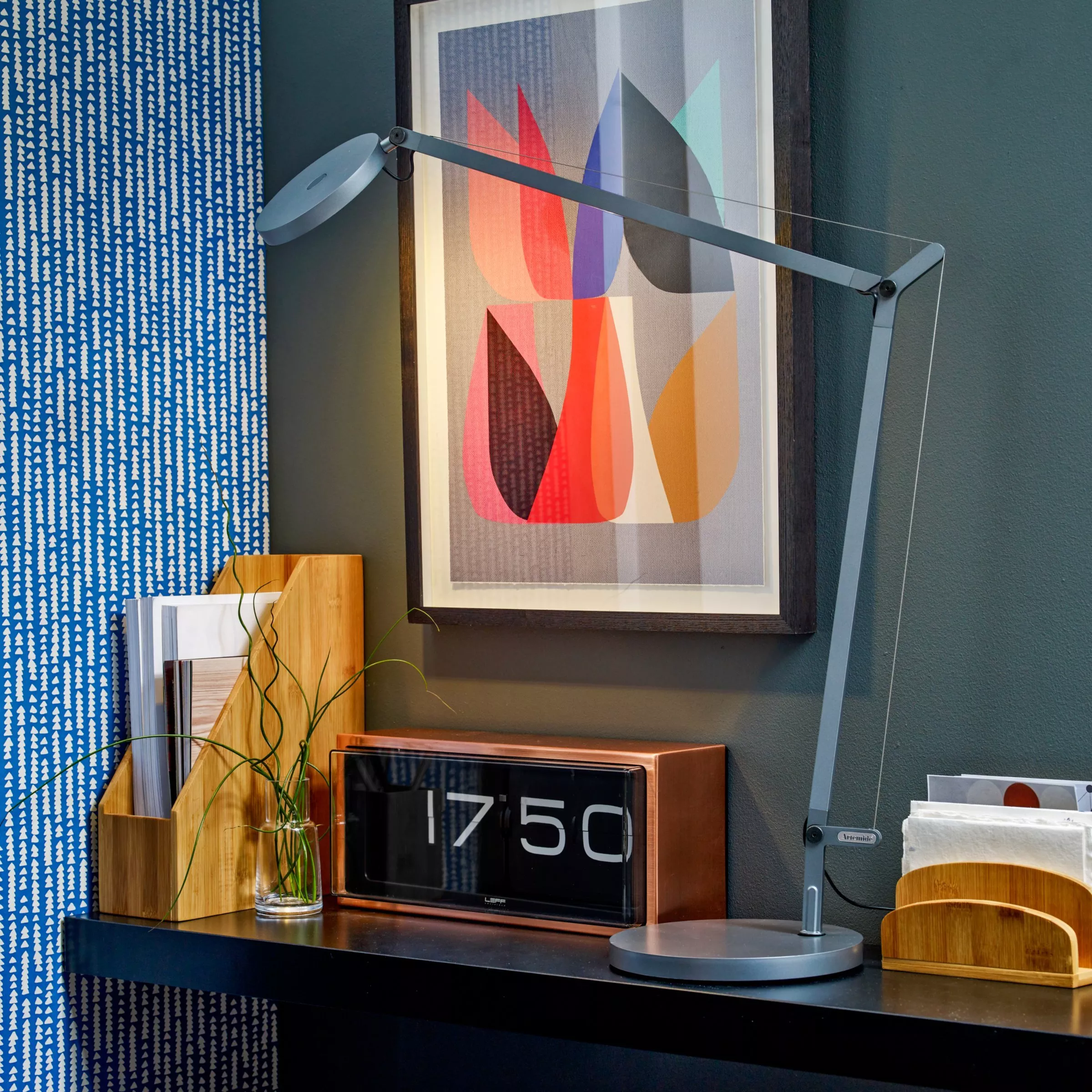 Modern home office shelf with adjustable desk lamp, framed abstract art print, and retro flip clock display