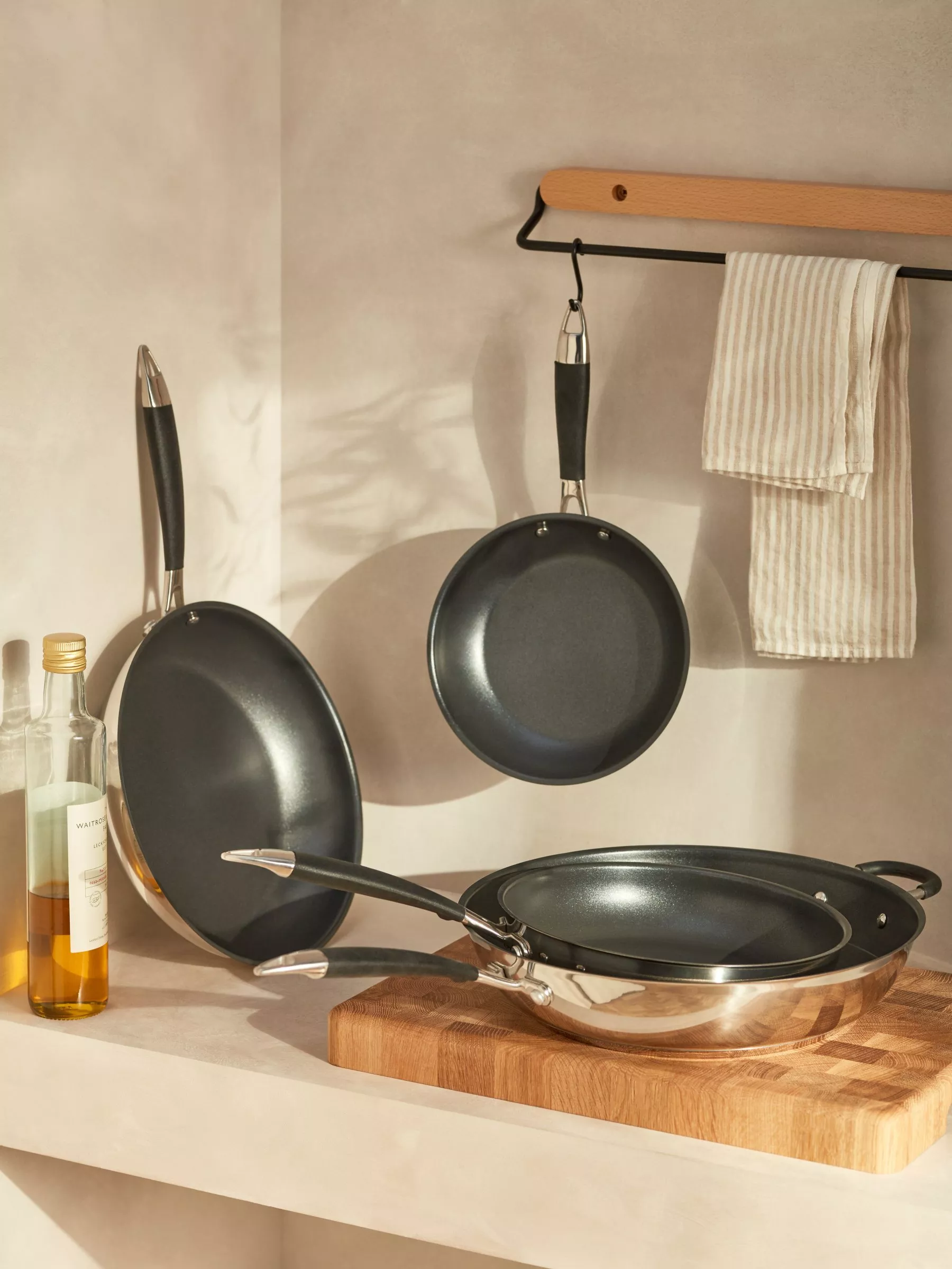 Four frying pans arranged on a shelf
