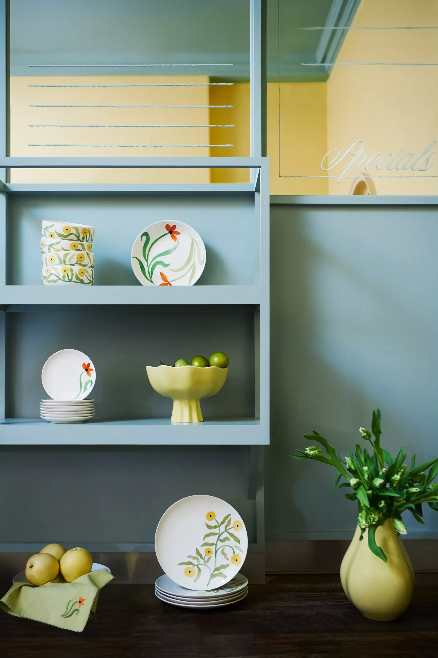 Decorative chocolate eggs on a white stand, surrounded by purple flowers and blue ribbon. Text reads "New Now".
