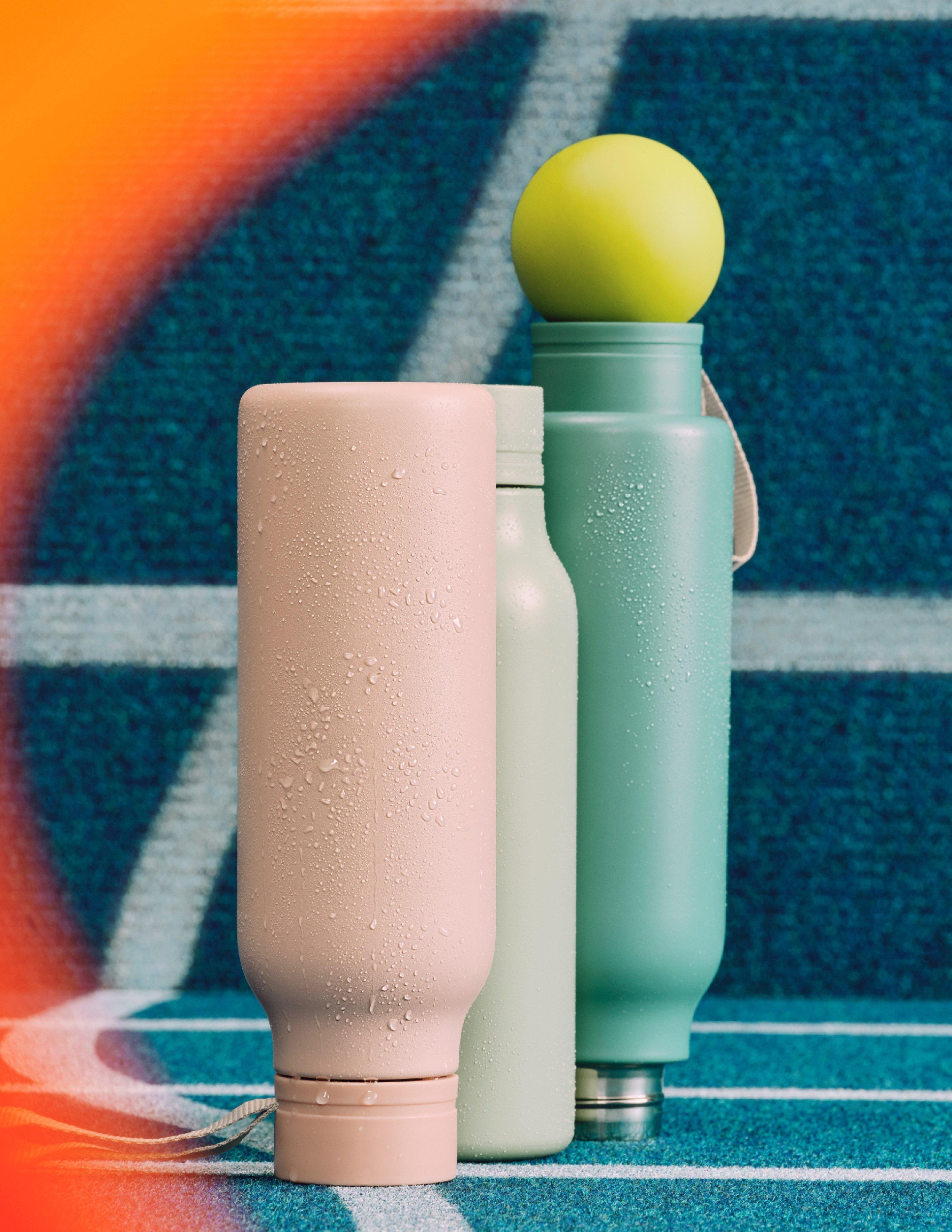 product shot of 2 water bottles with a tennis ball sitting on top of one