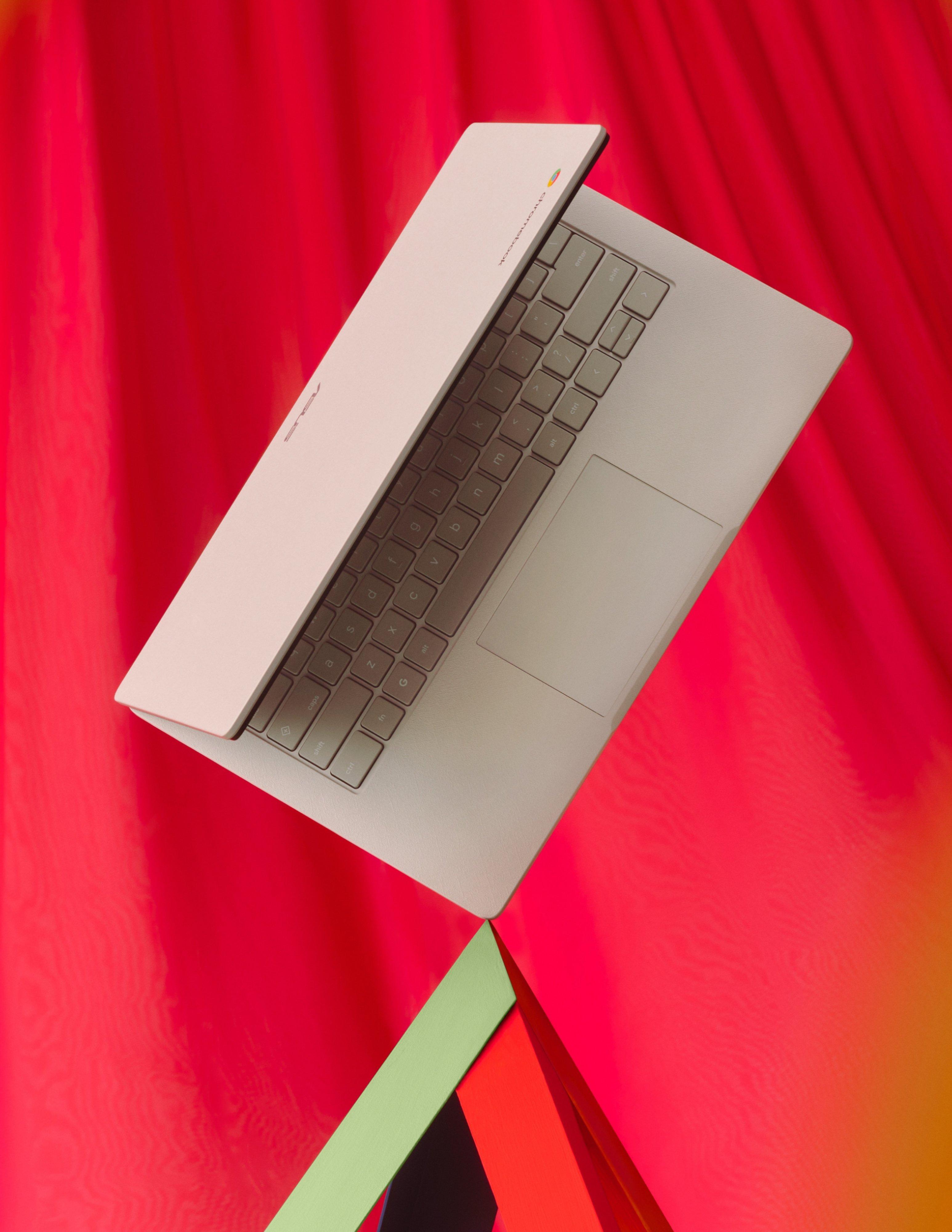 product shot of a laptop on traiangle plinth and a red fun background