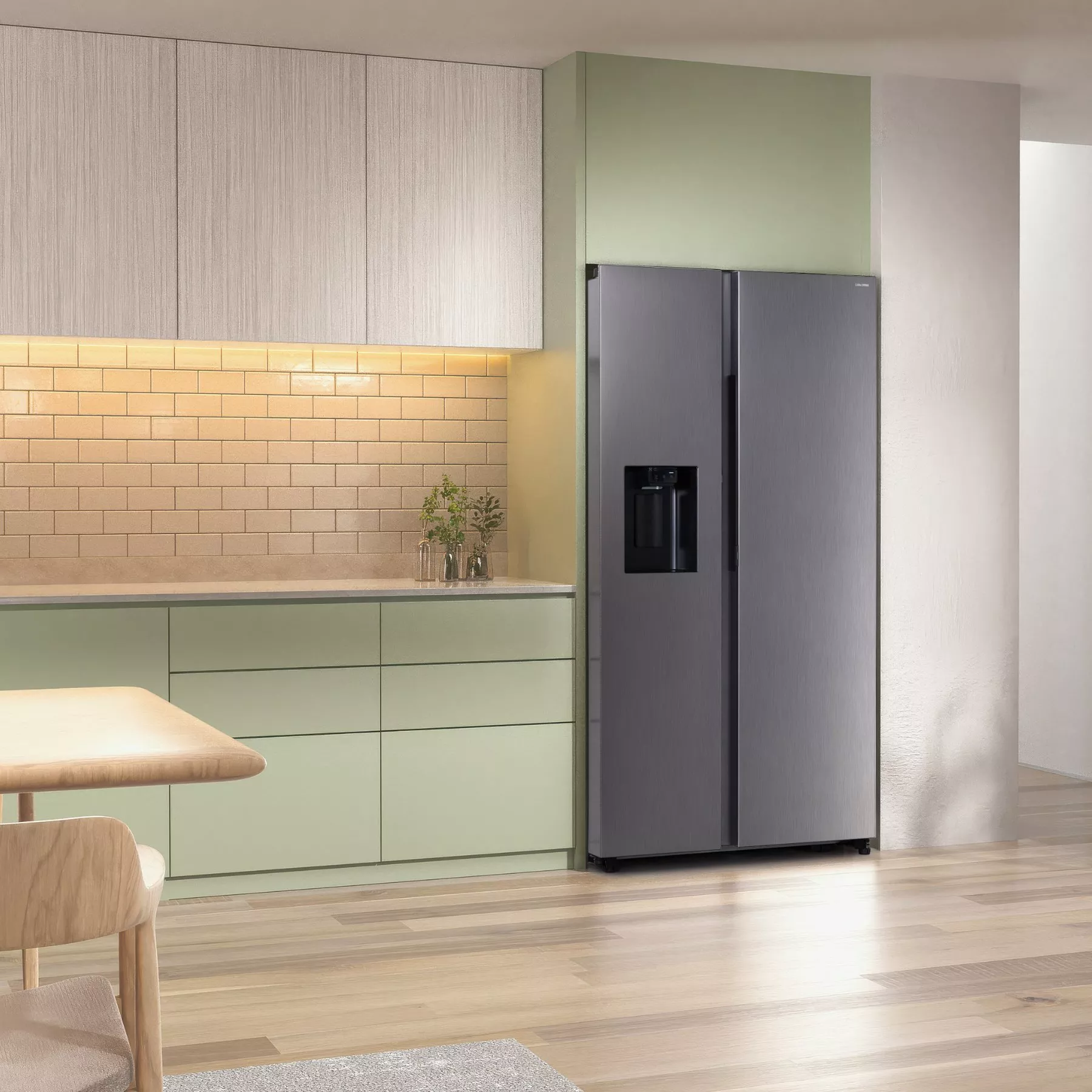 Modern kitchen with grey fridge, mint green cabinets, wooden table, and beige tiled backsplash. Bright lighting.