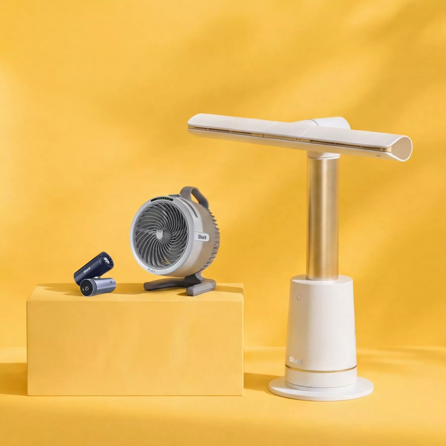 Shark portable fan and tower air cooler on yellow background, modern home cooling appliances product shot
