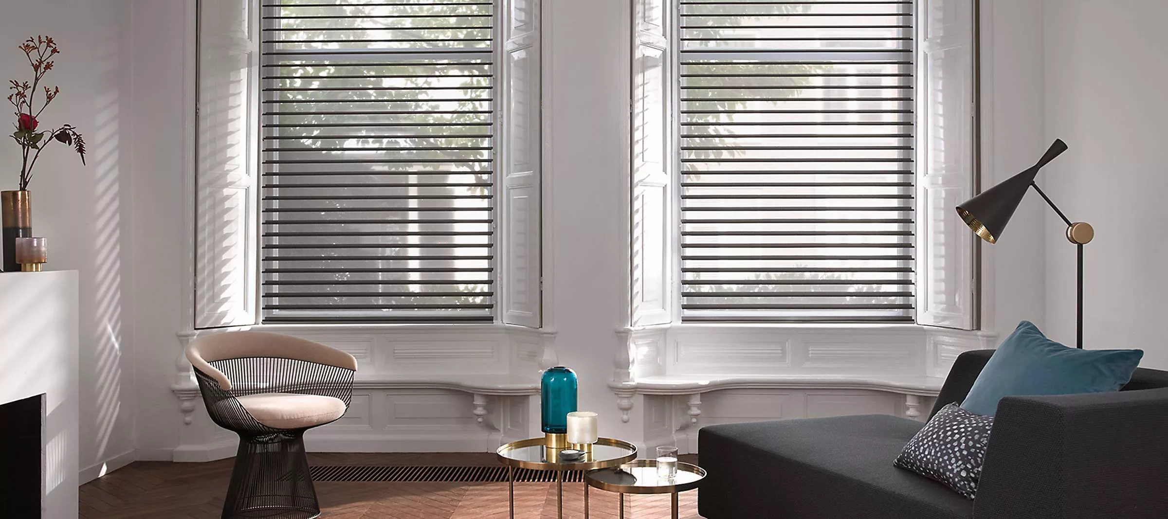 Patterned roller blind on a window, modern home interior with framed wall art and soft daylight filtering through