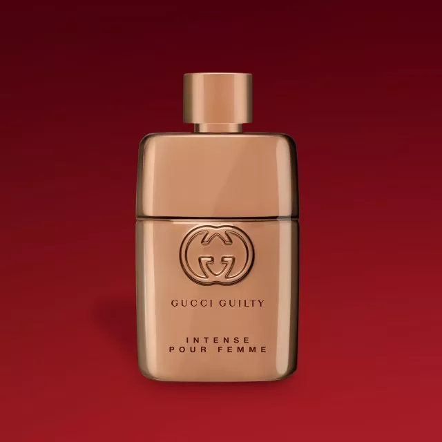 Gucci Guilty Intense Pour Femme perfume bottle in rose gold, luxury women’s fragrance on deep red background