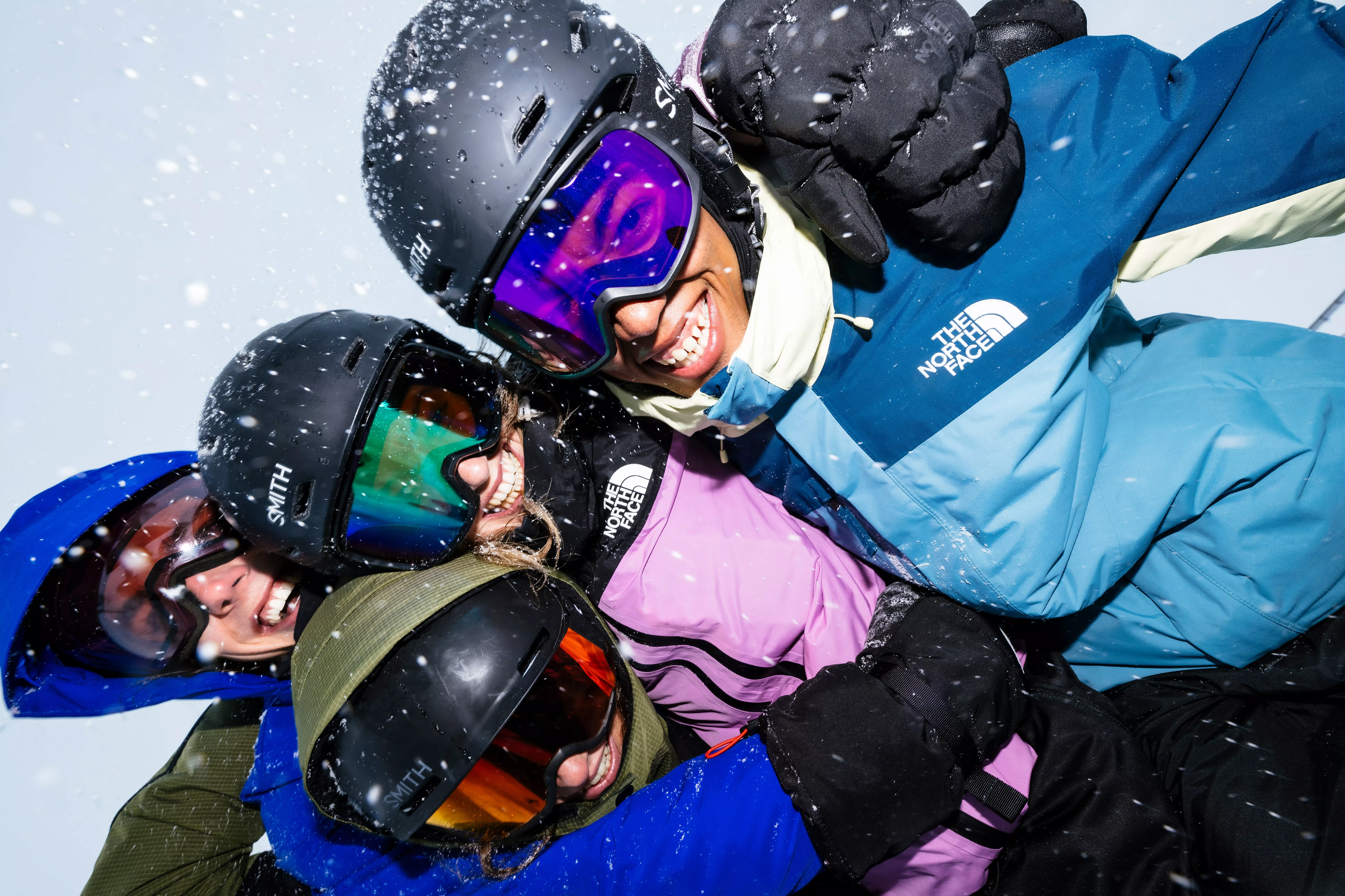 A group of friends in ski wear smiling at the camera