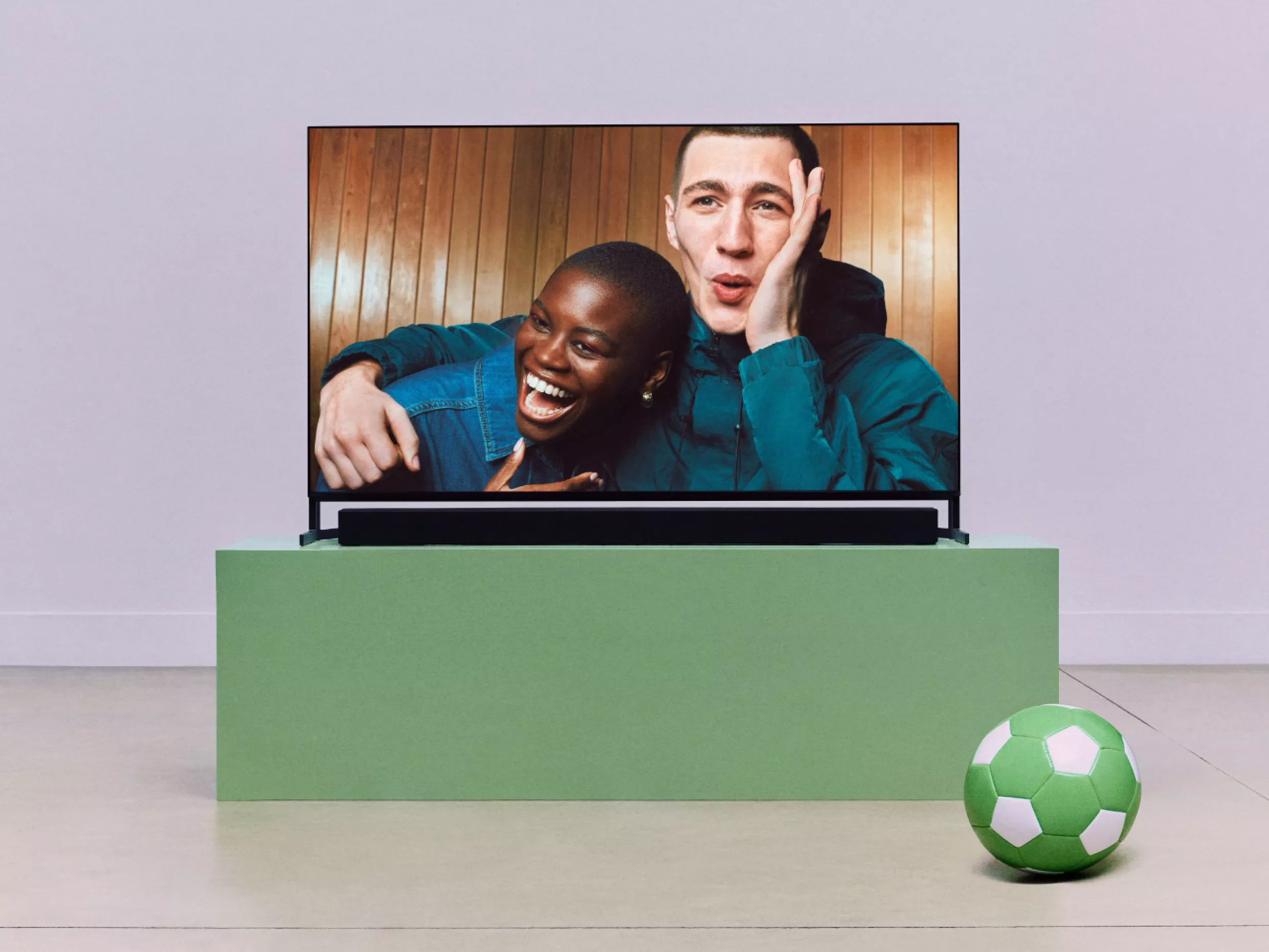 Friends laughing on a smart TV in a modern living room with green football, home entertainment and streaming concept