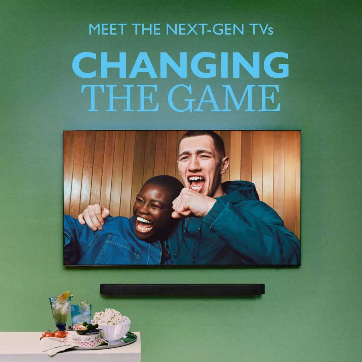 Wall-mounted next-gen TV and soundbar with friends cheering, plus snacks and drinks beneath, promo poster design