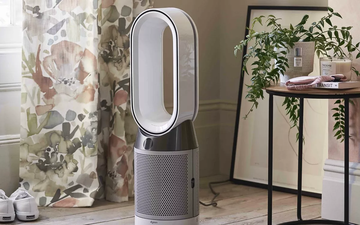 Dyson bladeless air purifier fan in modern living room beside plant table, floral curtains and framed artwork