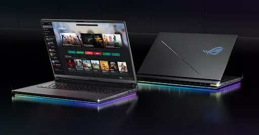 Two modern laptops, one displaying a vibrant race game, both feature sleek silver designs on a black background.