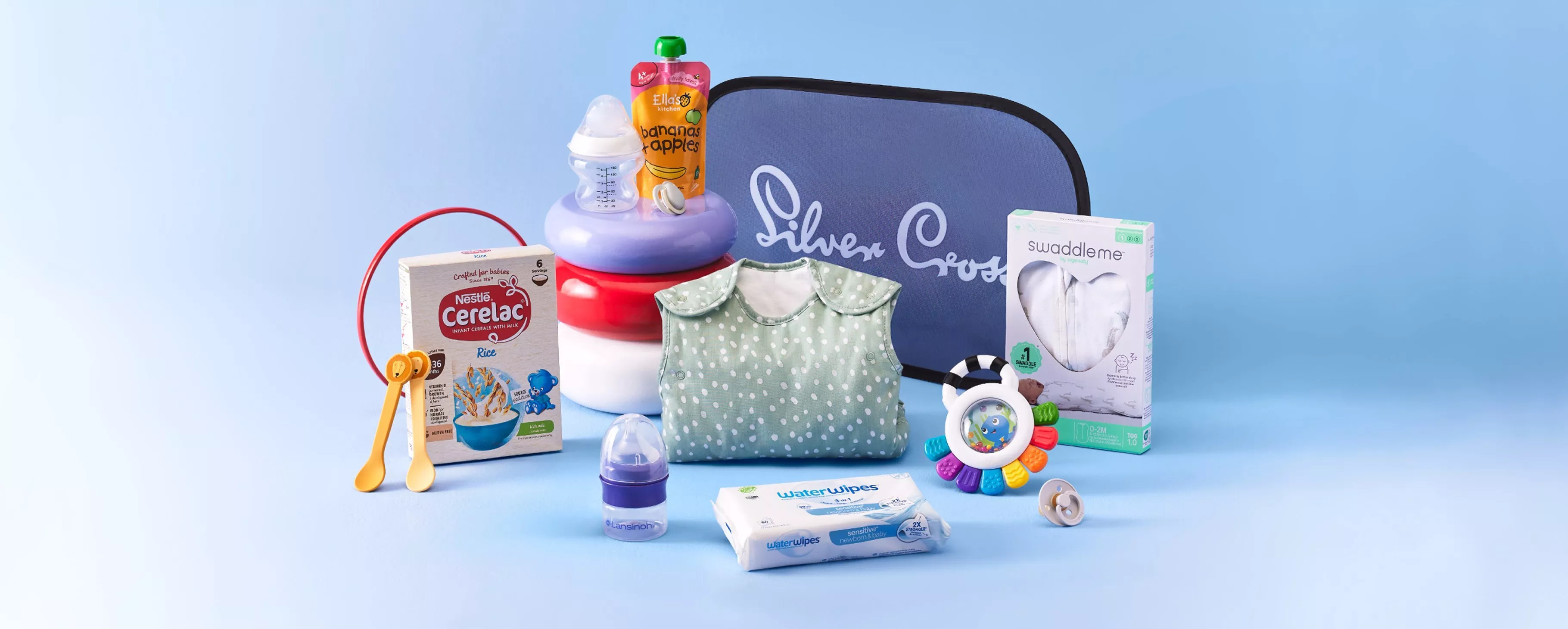 Silver Cross baby gift set with sleeping bag, swaddle, bottle, wipes, pacifier, rattle and baby food.