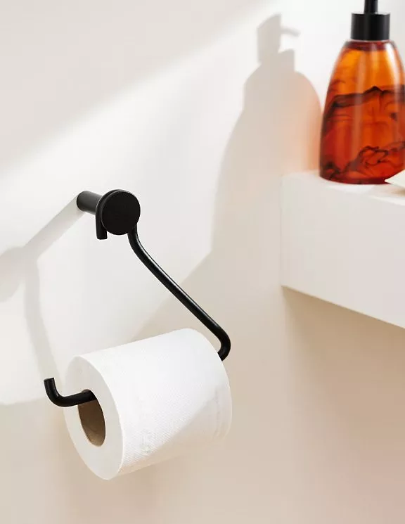 Toilet roll on a black toiler roll holder attached to the wall 