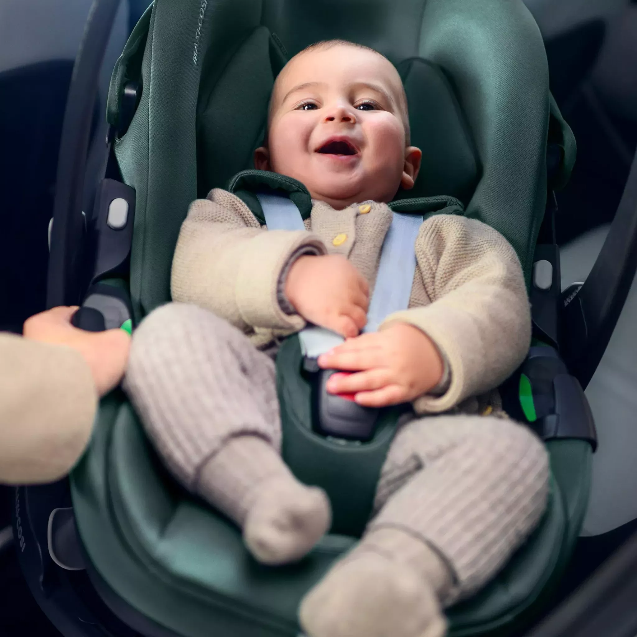 baby smiling while buckled in a car seat