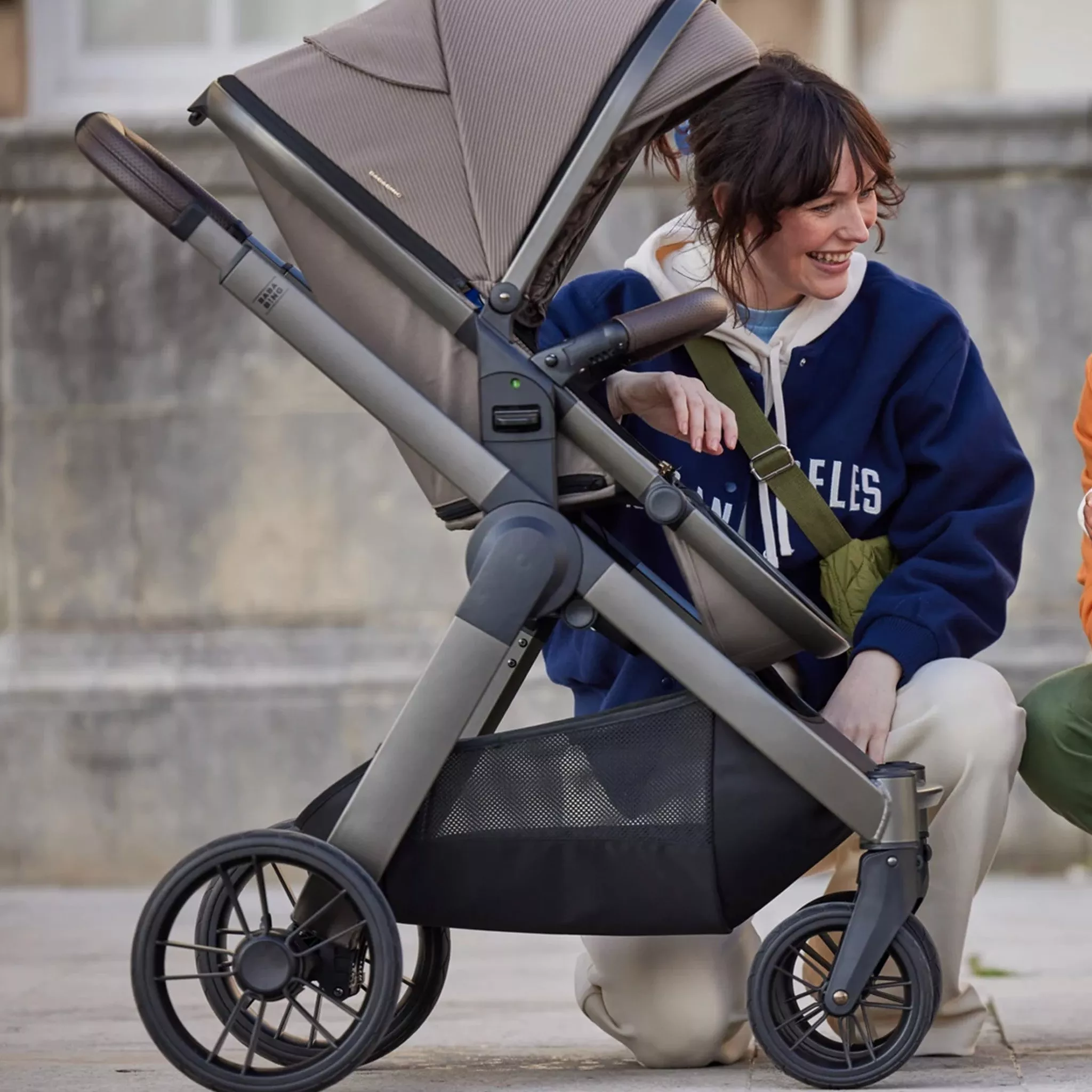 women kneeling down next to a pushchair
