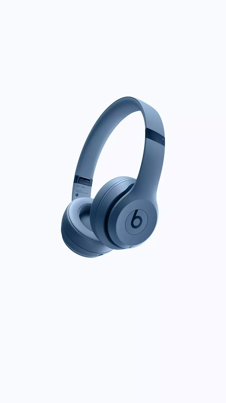 Blue Beats over-ear wireless headphones with cushioned ear cups, studio-style design, on a clean pale blue background