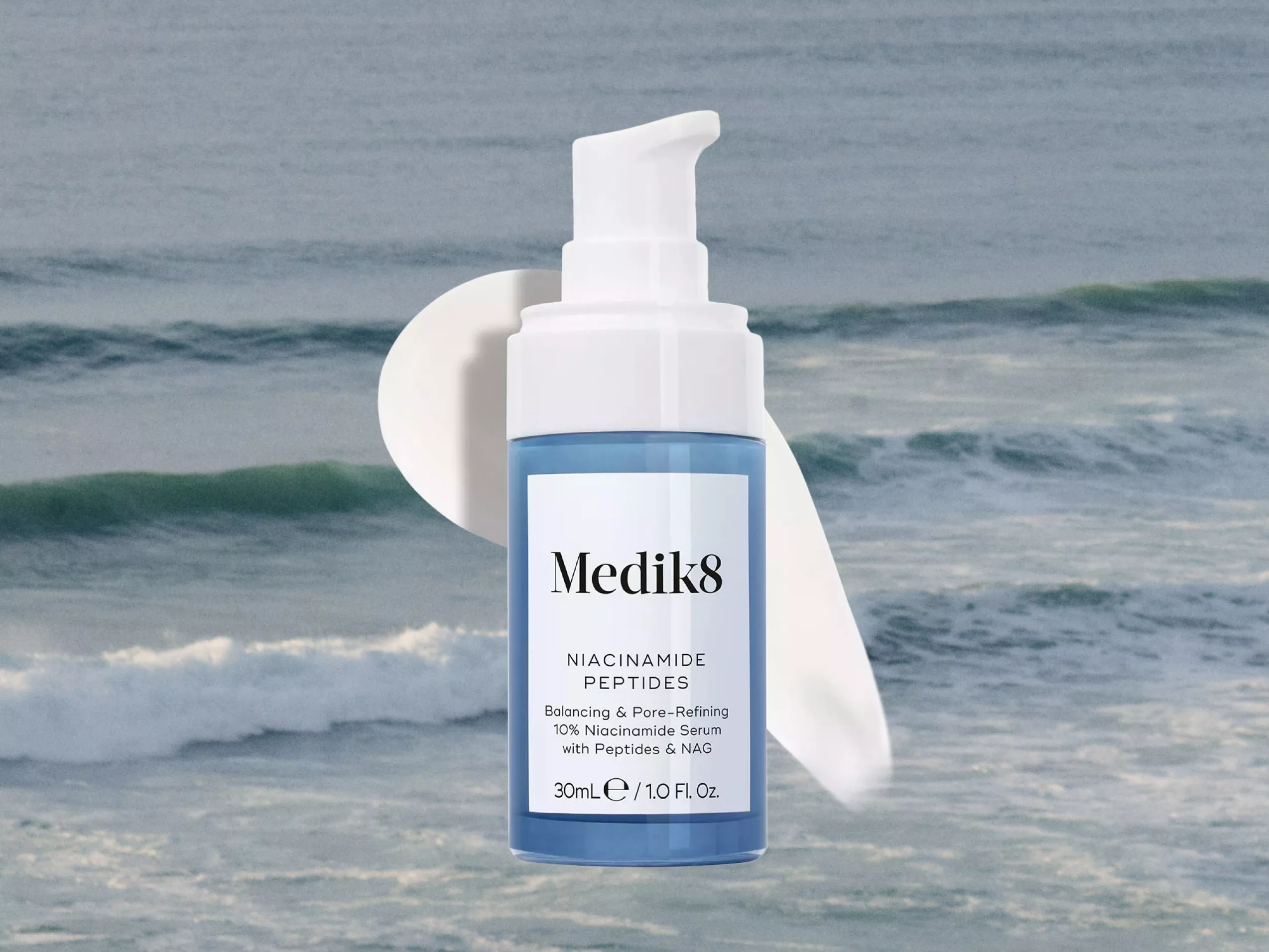 A Medik8 niacinamide serum bottle with a pump, set against a serene ocean wave background.